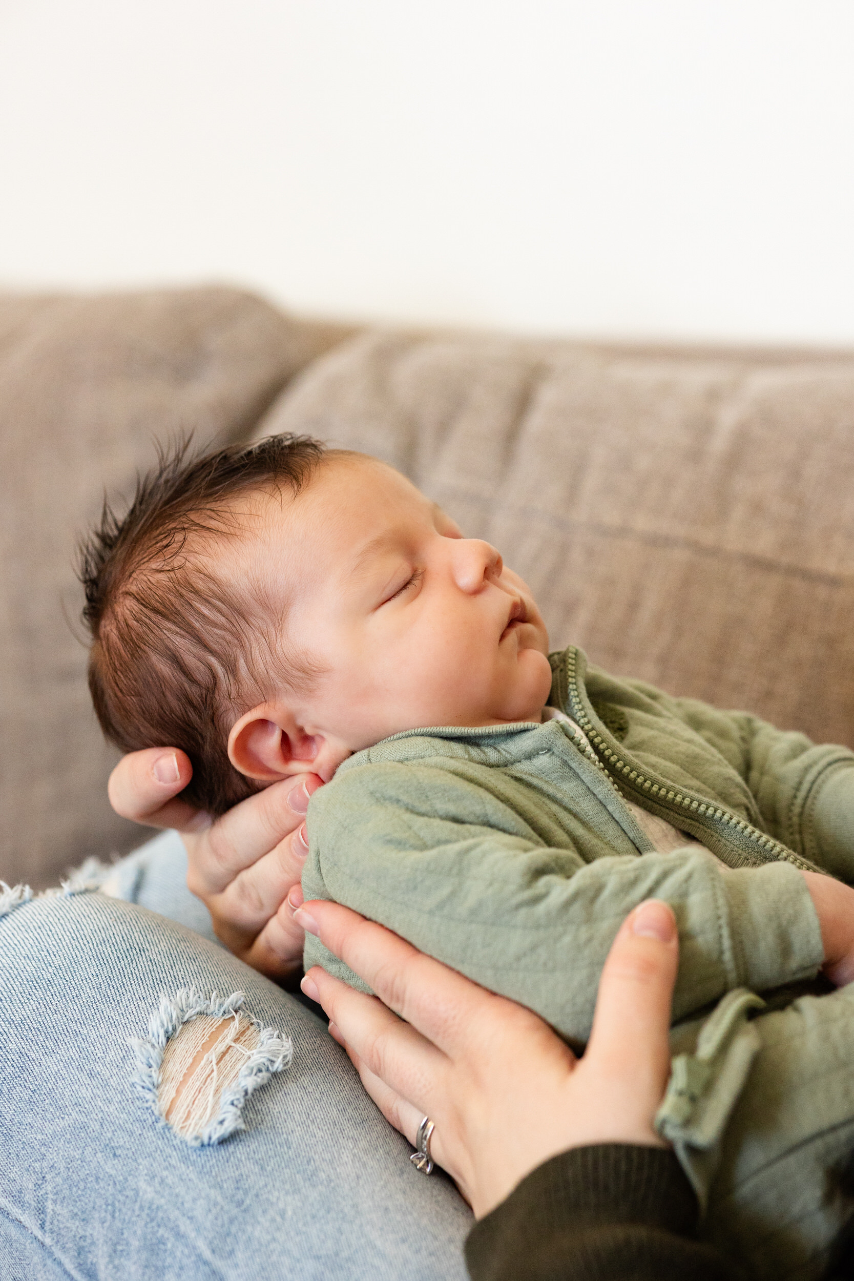Newborn baby sleeps in his mom's arms.