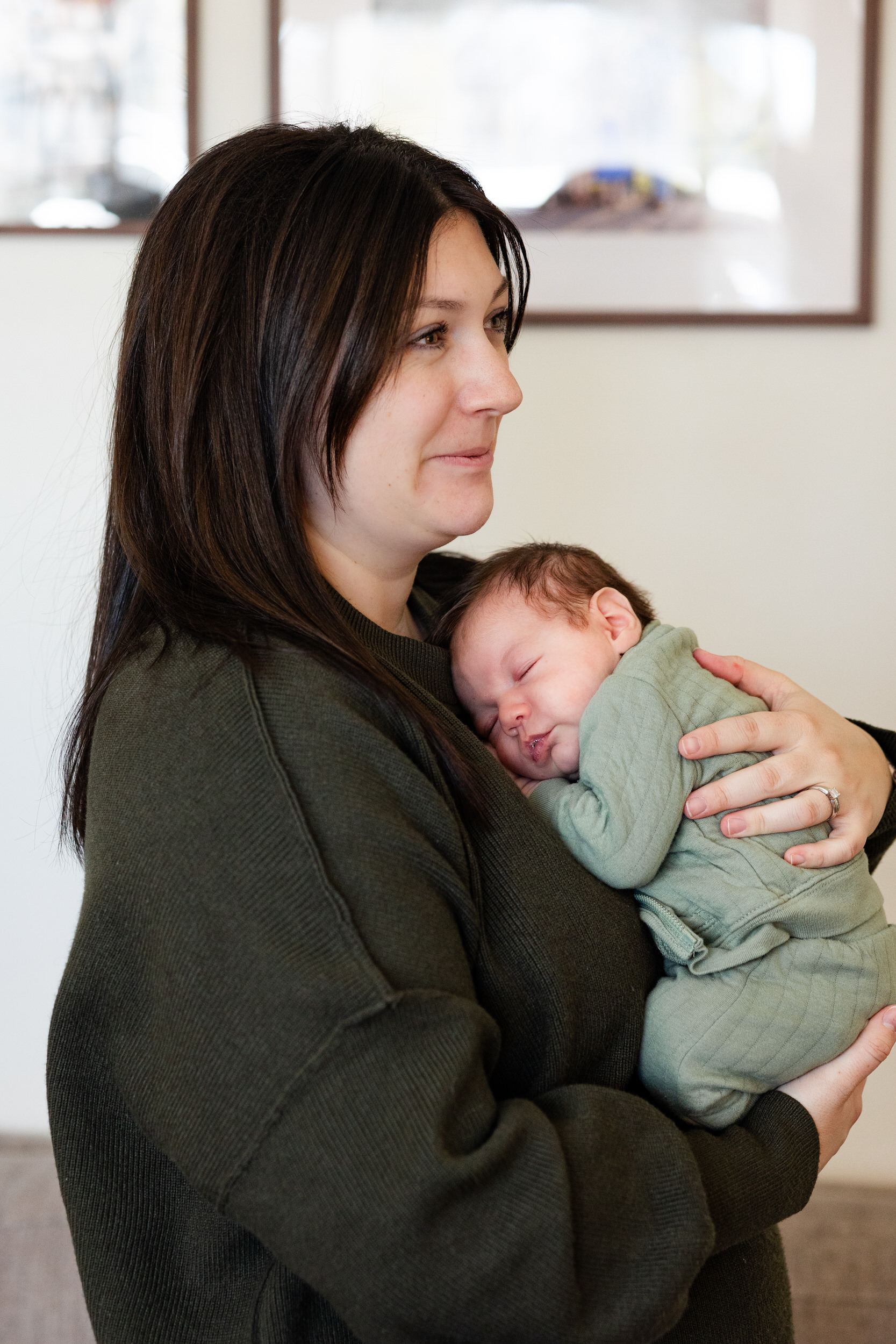 Newborn baby sleeps on his mom's chest.