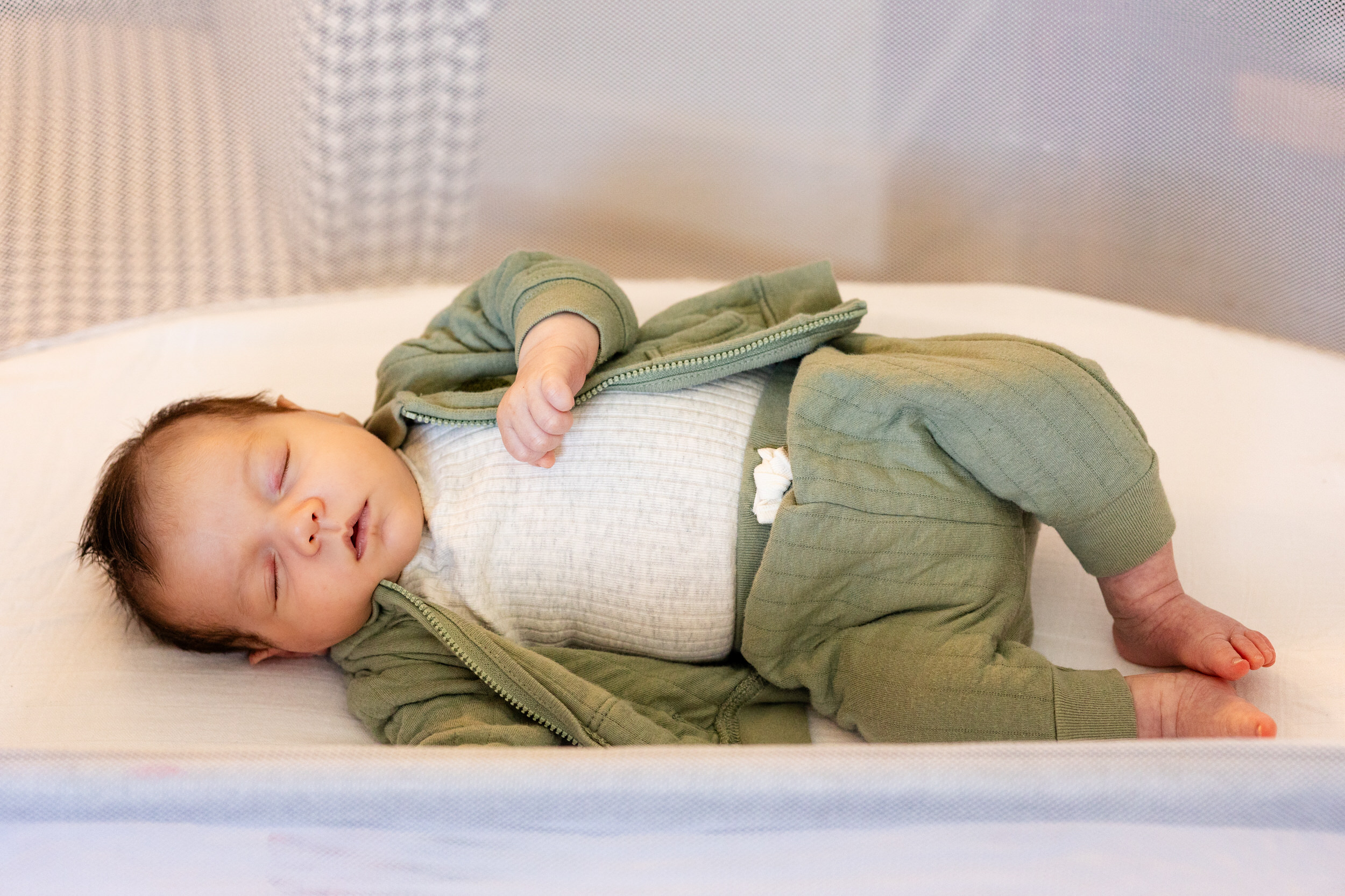 Newborn baby sleeps in his bassinet.
