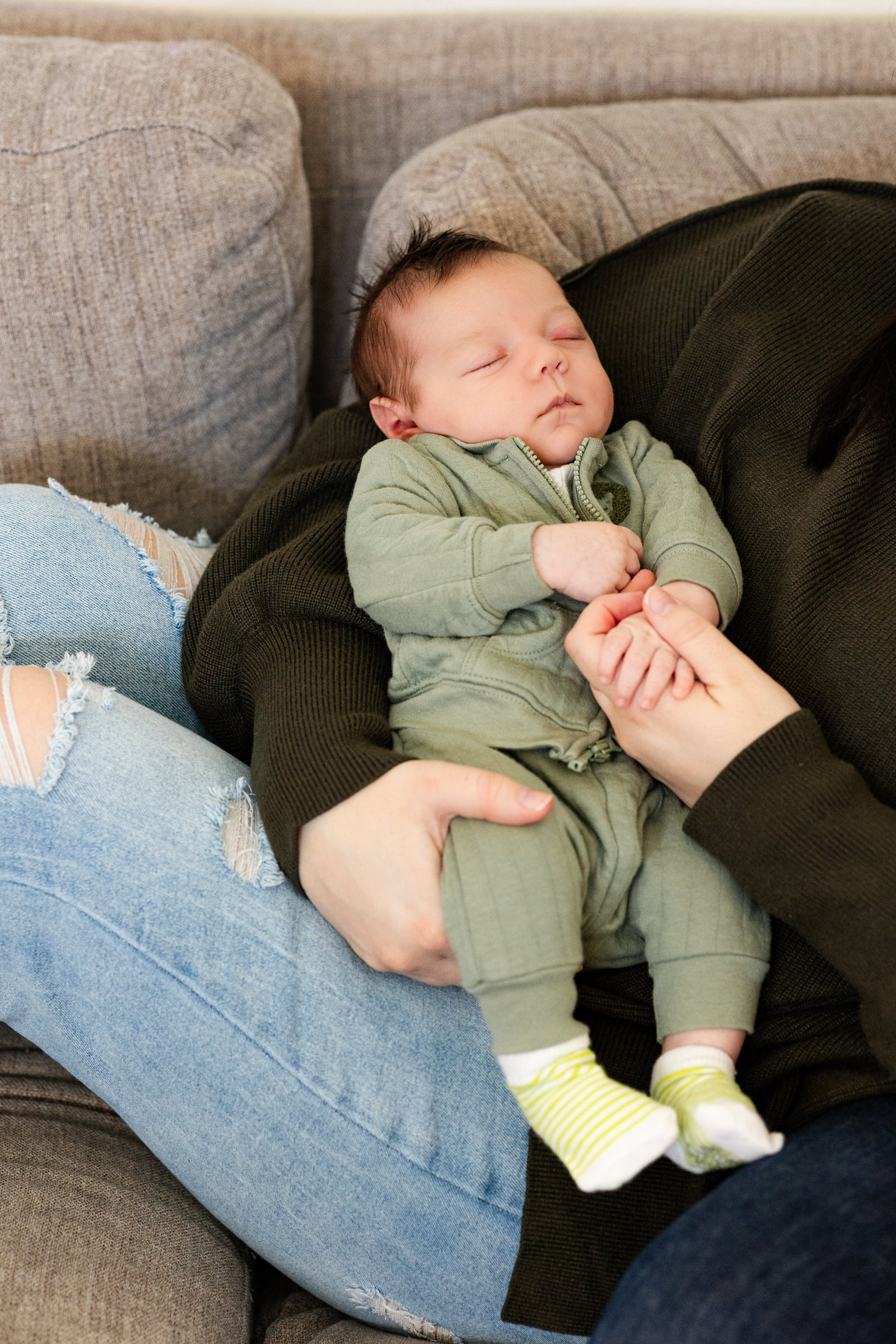 Newborn sleeps in his mom's arms.