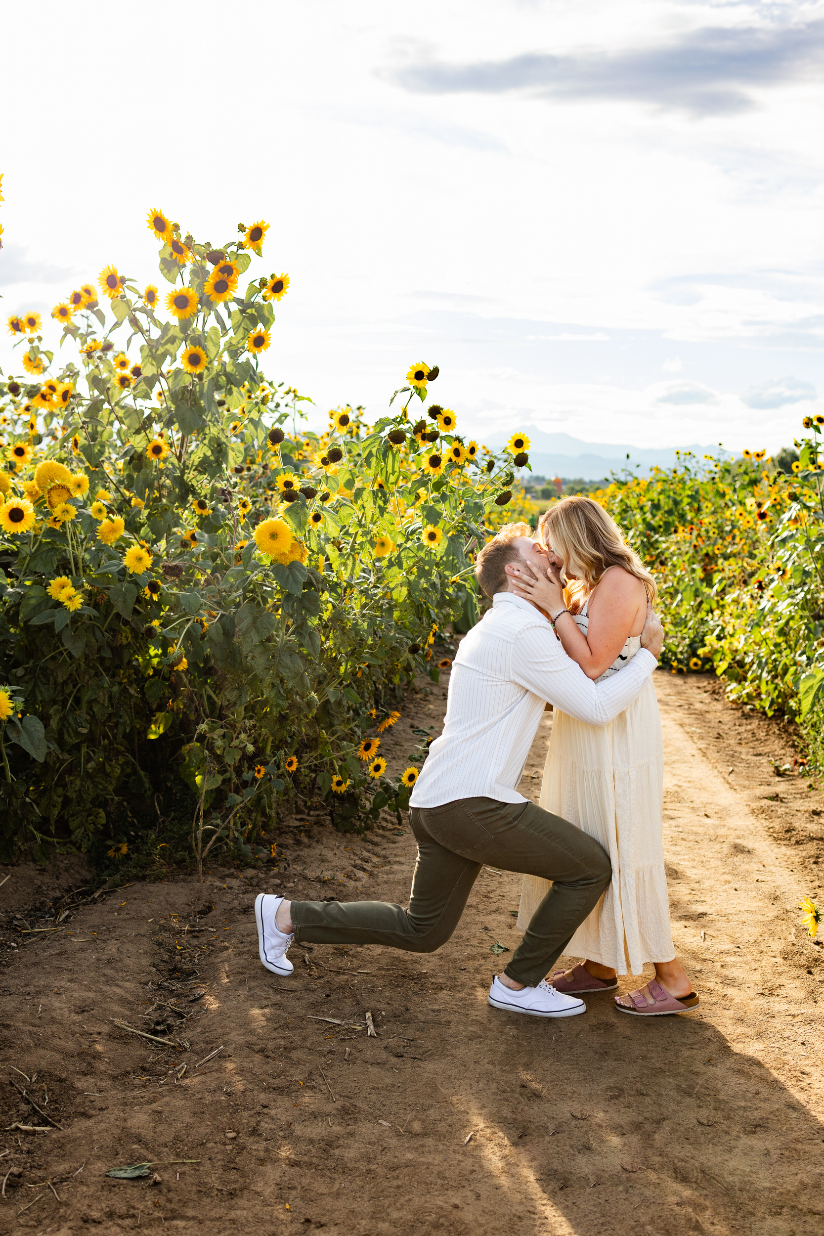 A man kisses his fiancée right after she accepts his proposal.