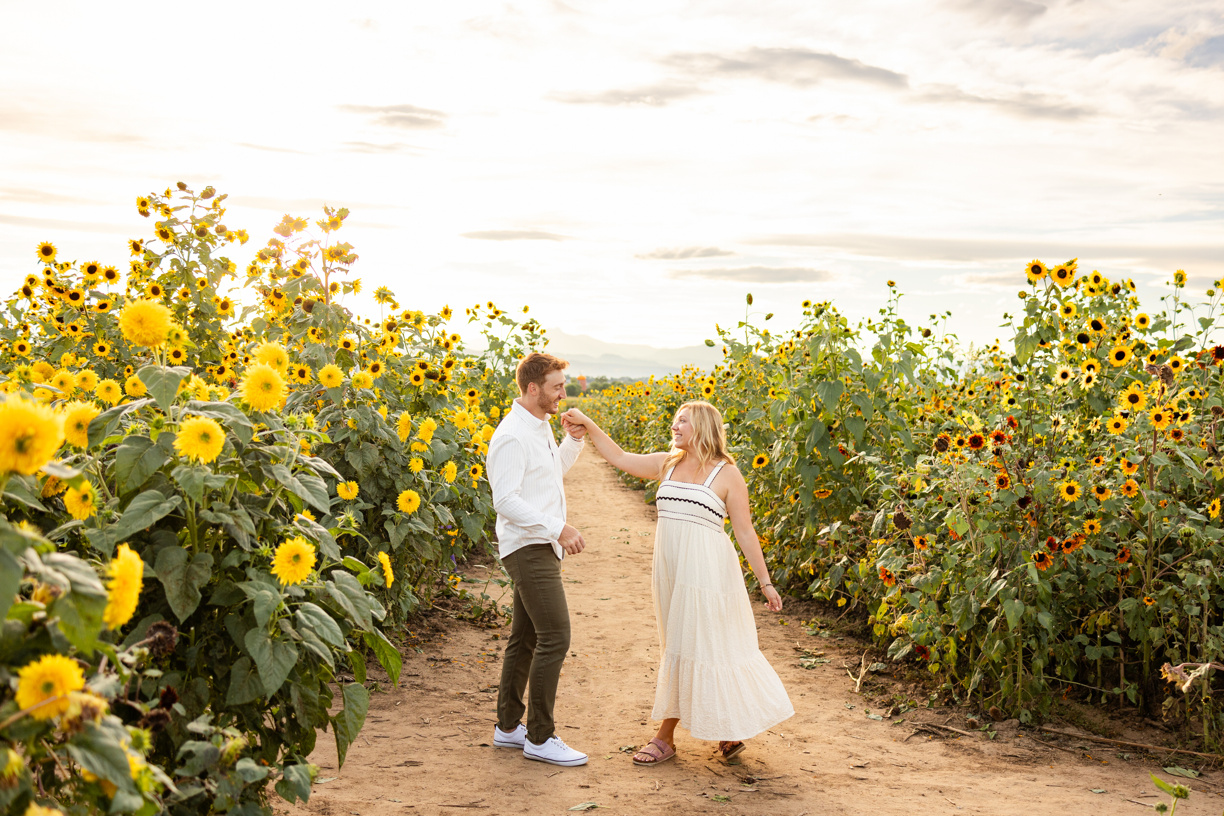 A man grabs his fiancé's hand and pulls her in for a kiss.