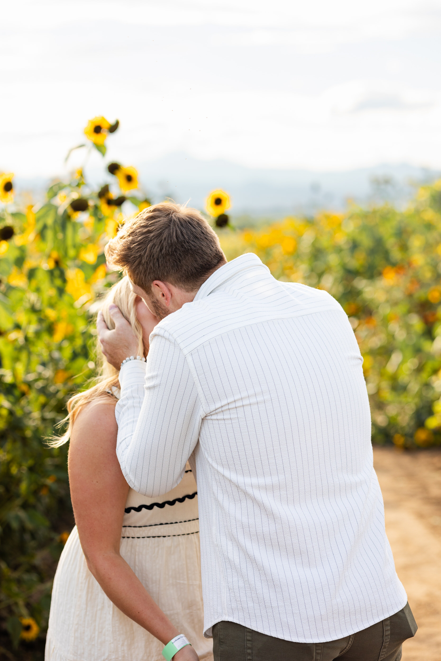 A man kisses his fiancée right after she accepts his proposal.