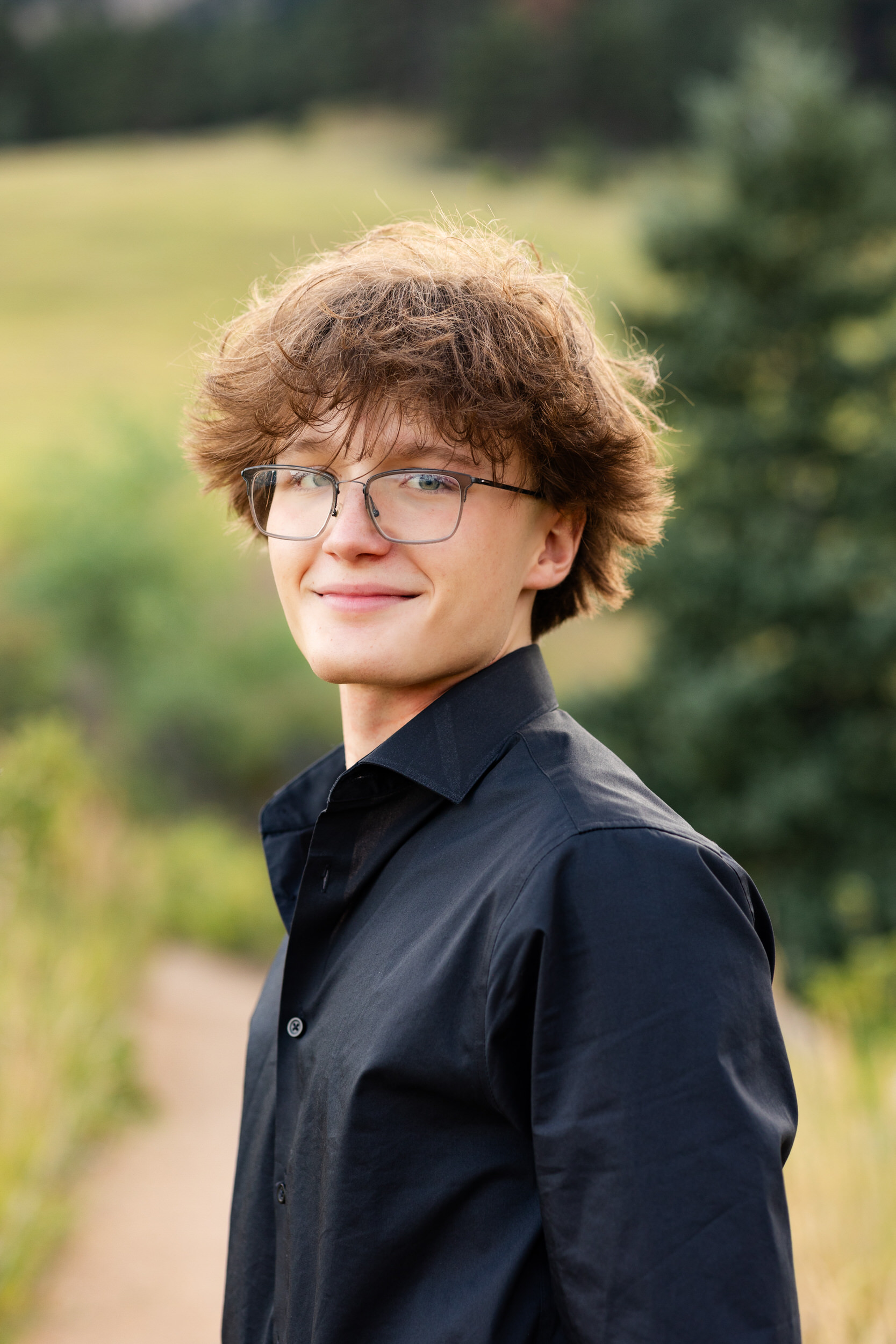A high school senior boy smiles at the camera.