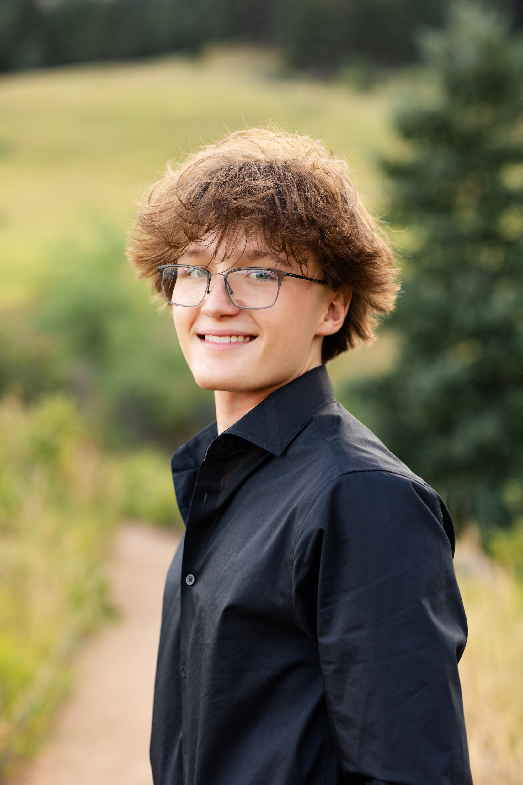 A high school senior boy smiles at the camera.