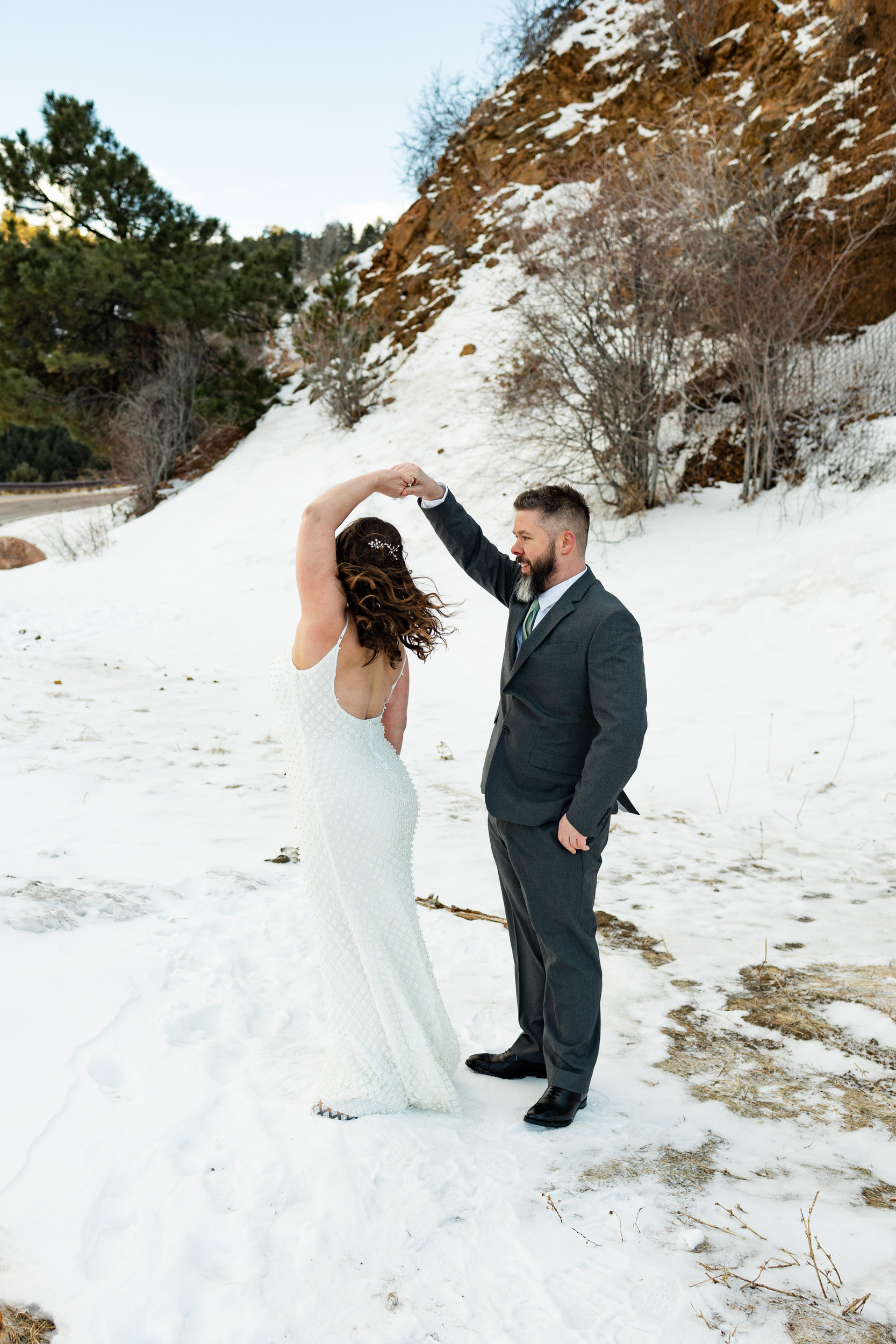 A husband twirls his wife in the snow.