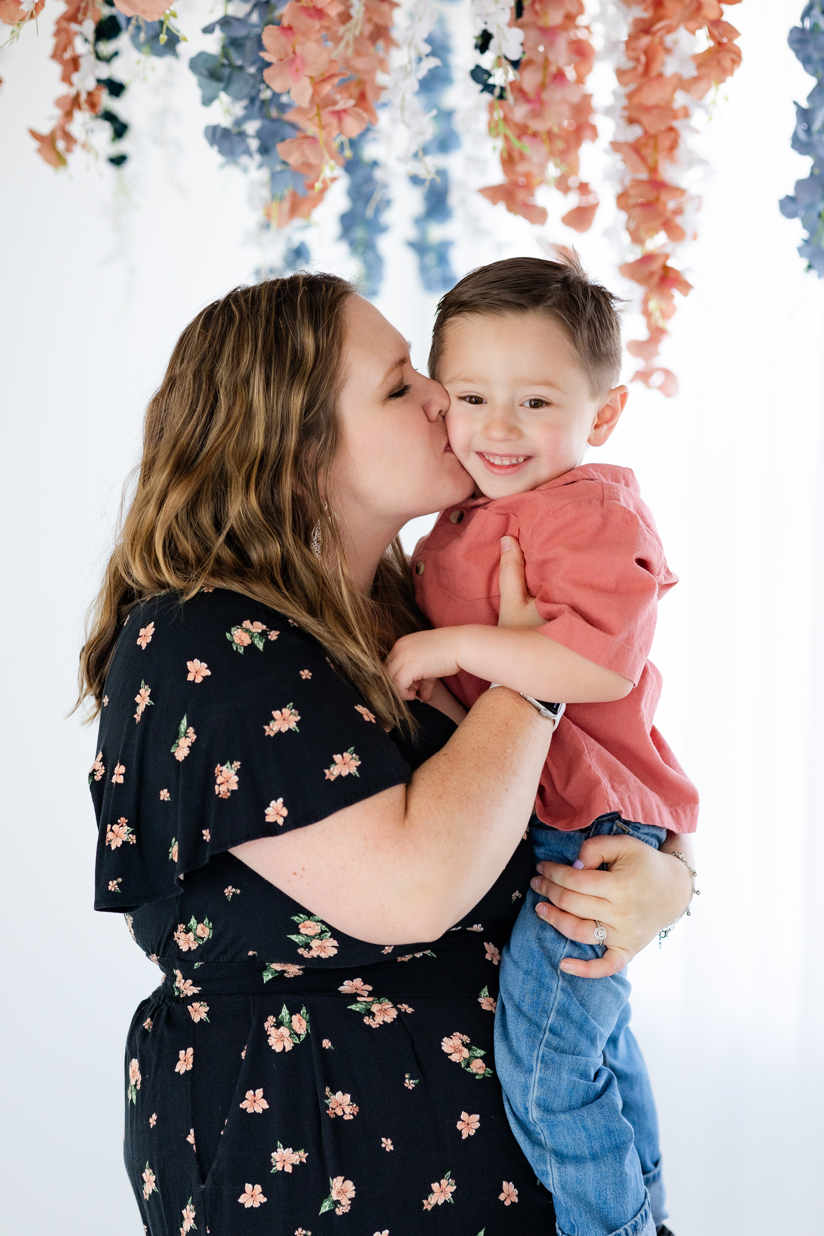 A mom kisses her young son's cheek.