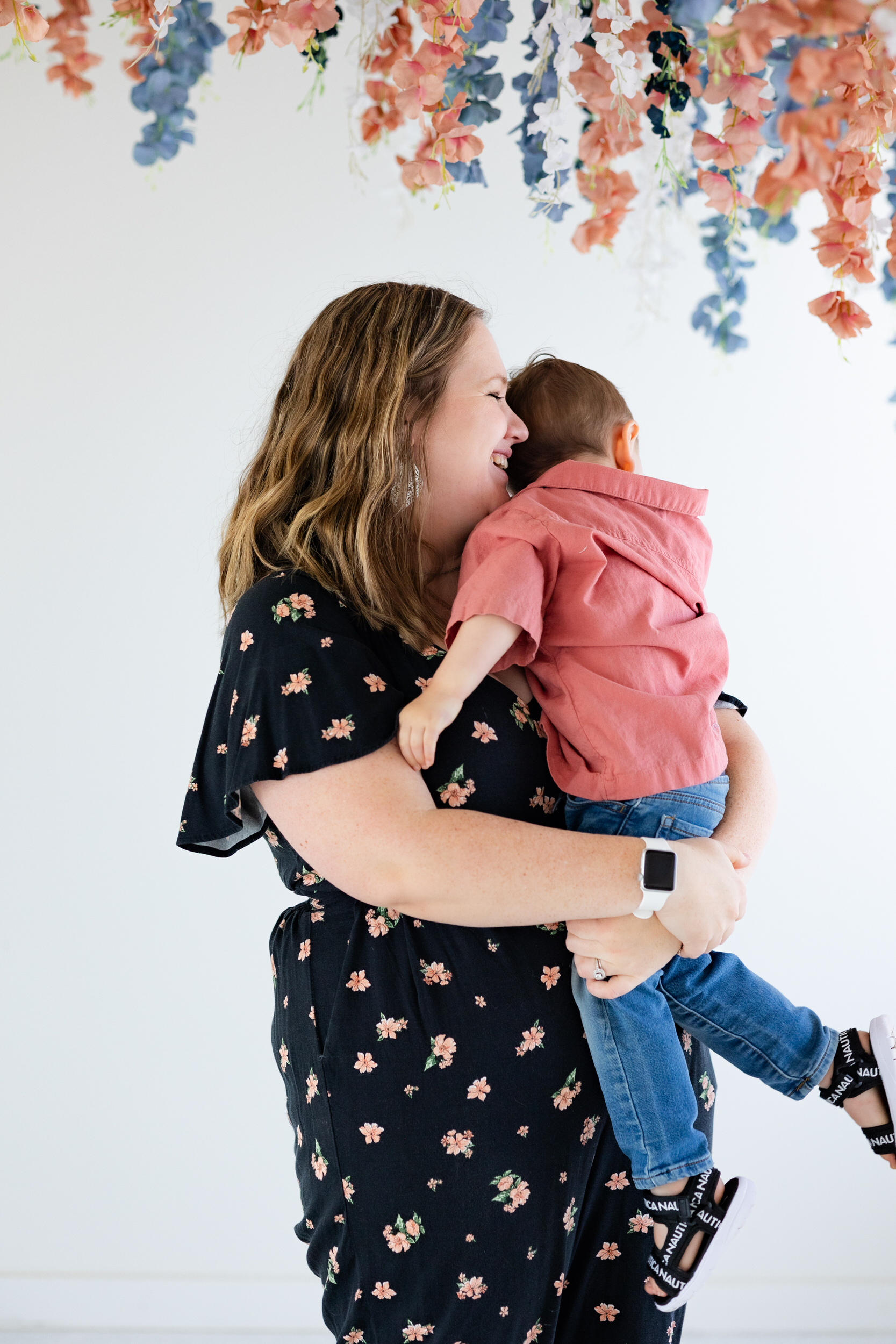 A mom holds and hugs her toddler son.
