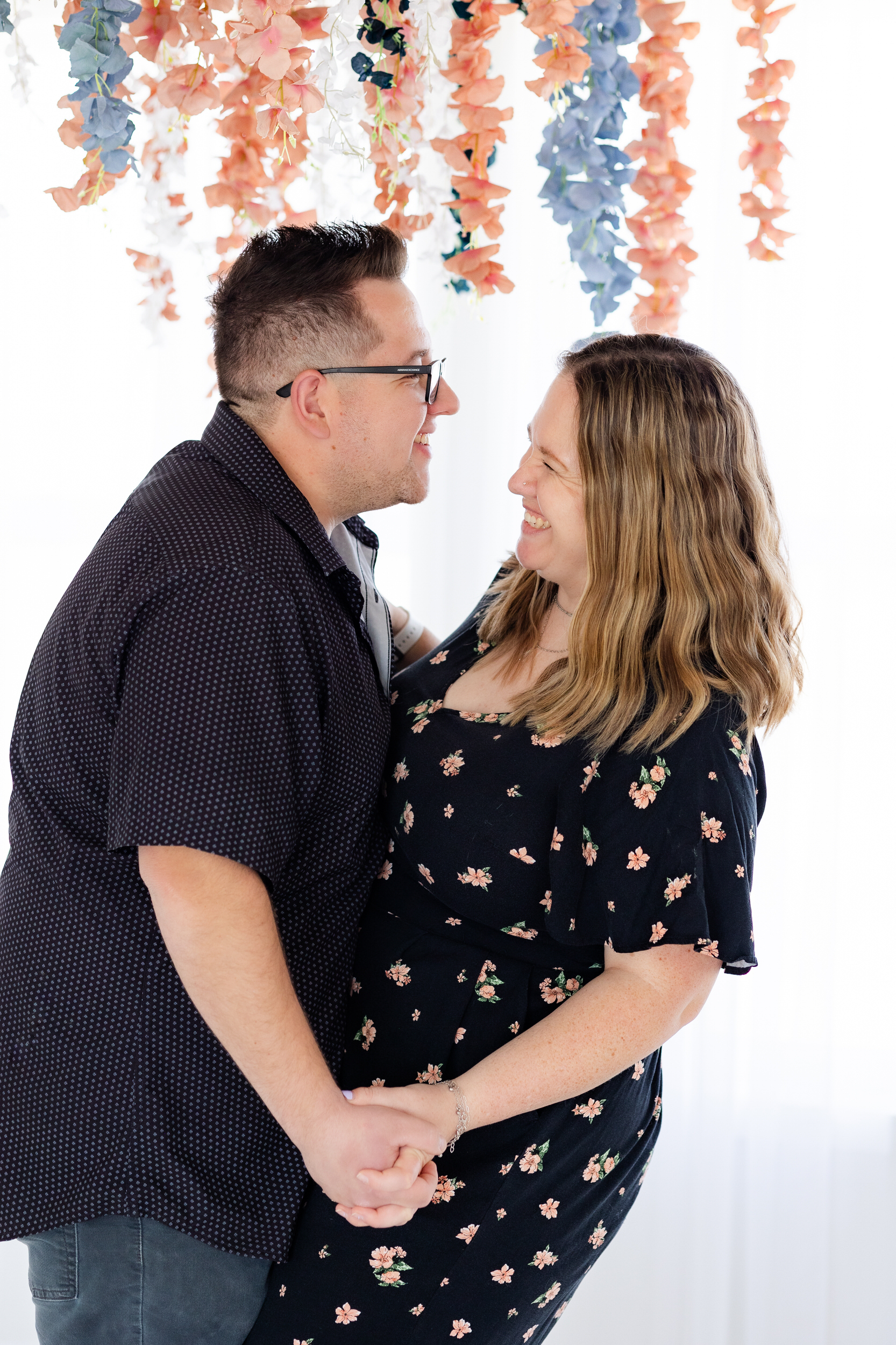 A husband and wife hold each other close and laugh together.