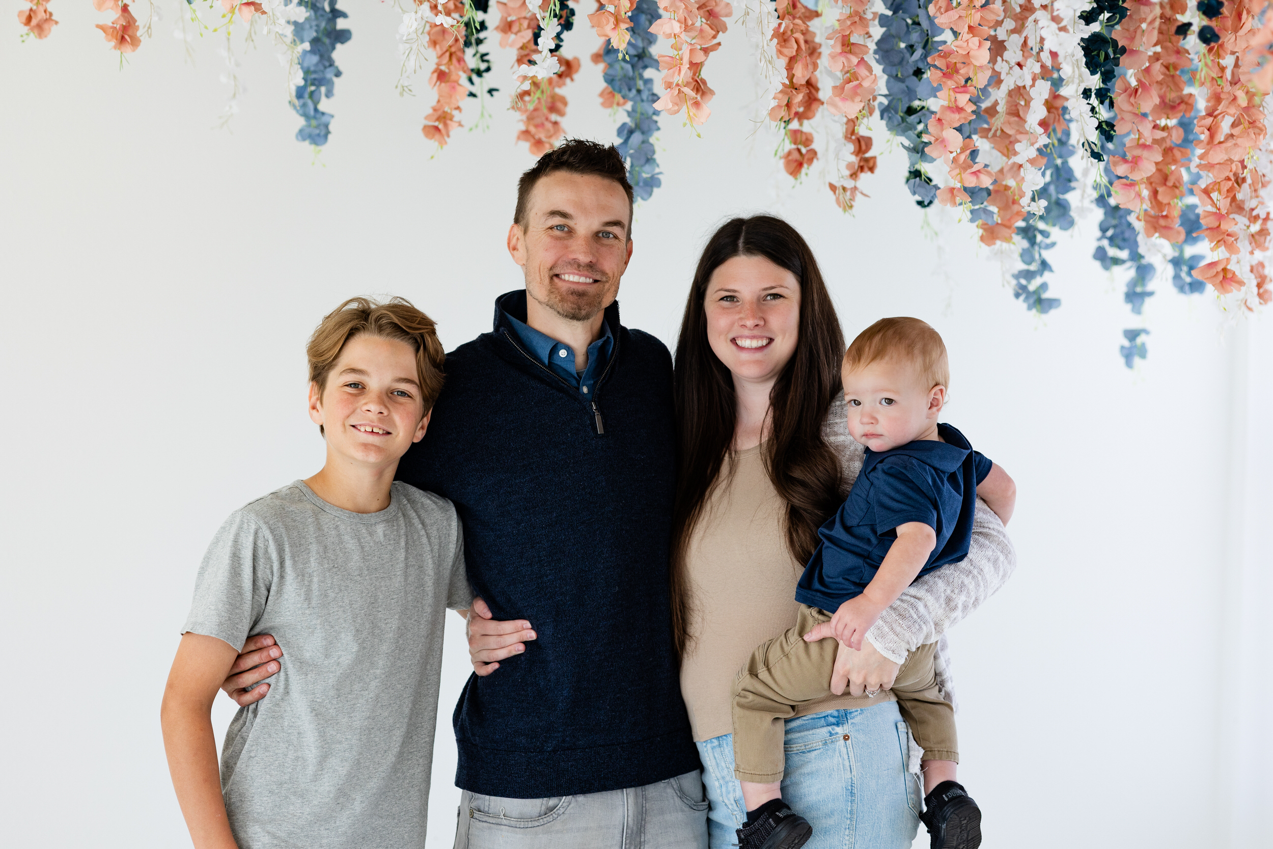 A family of four smiles at the camera.