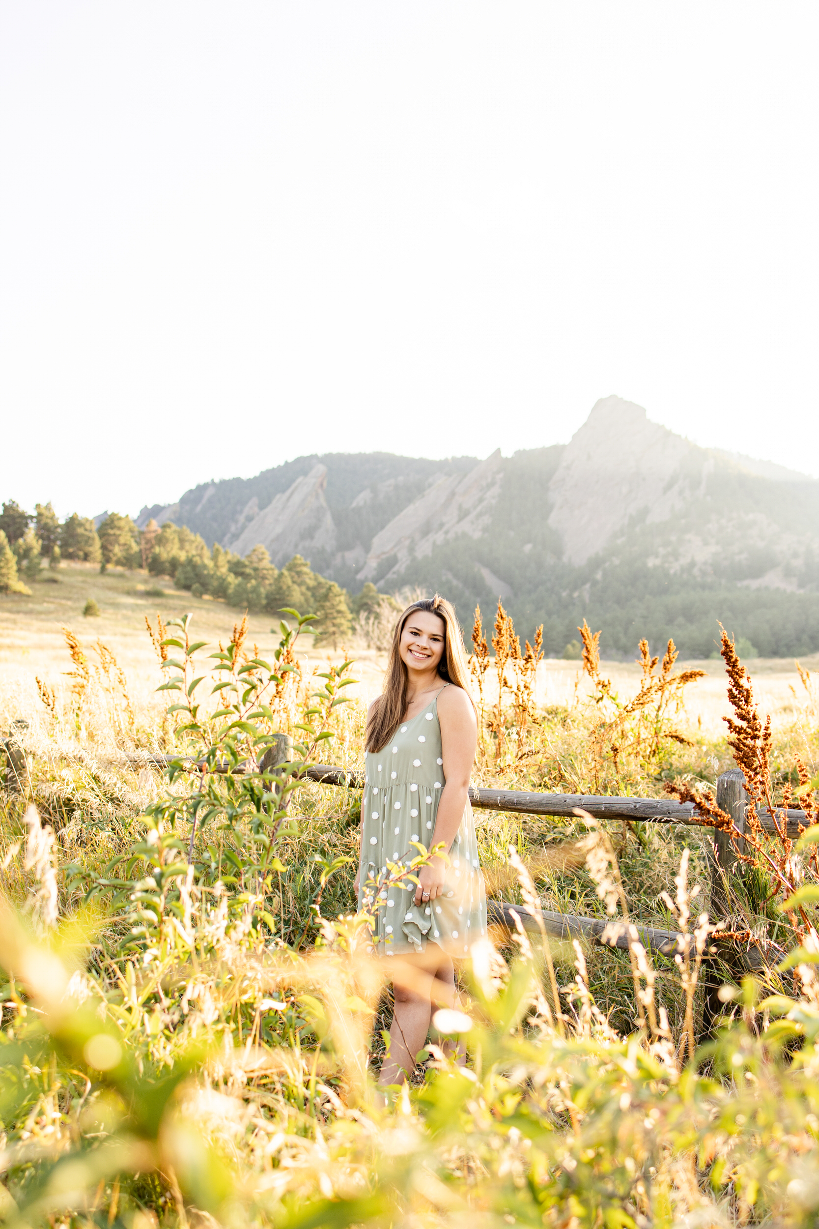 Woman standing in a field at sunset.