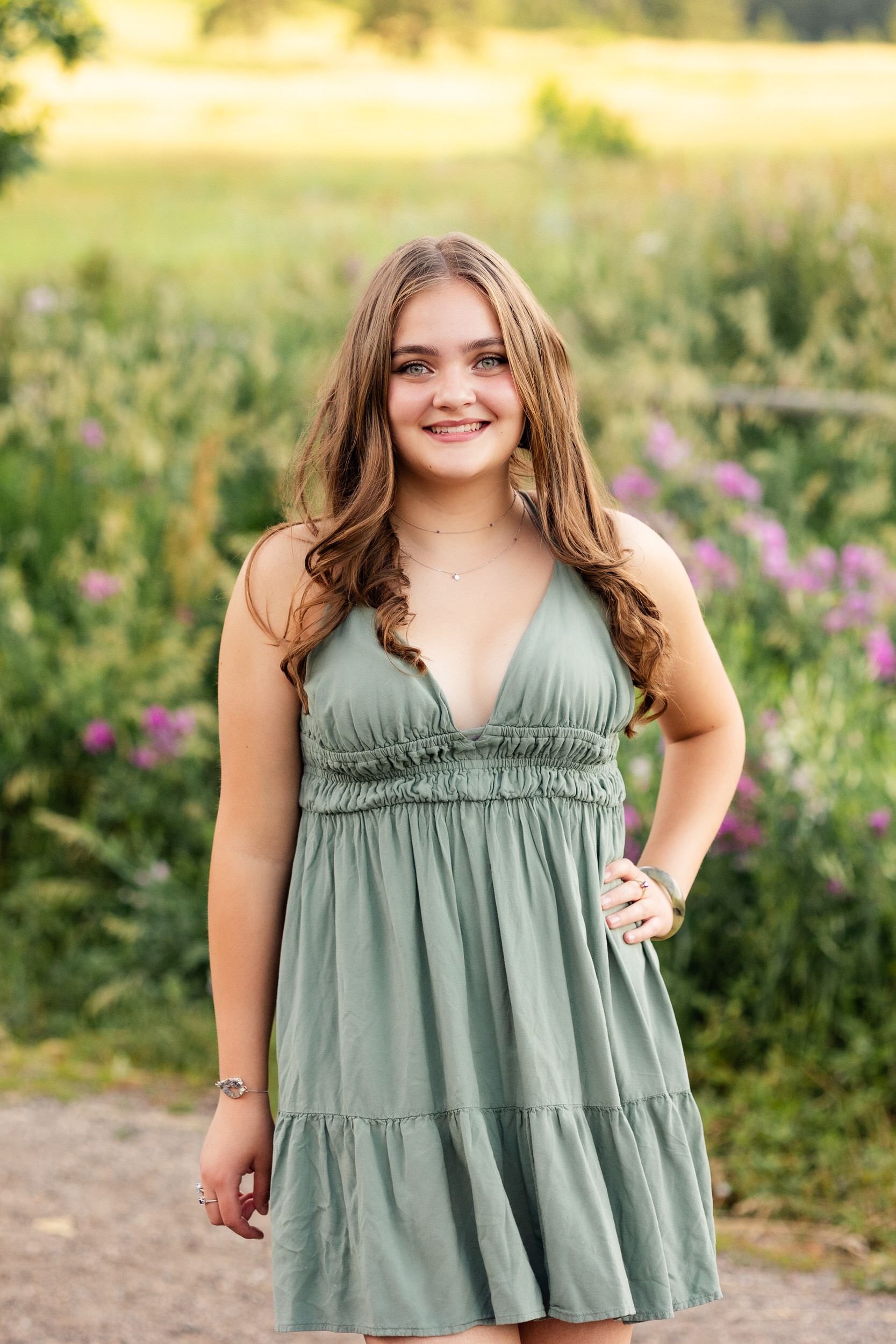 A woman in a green dress walks toward the camera.