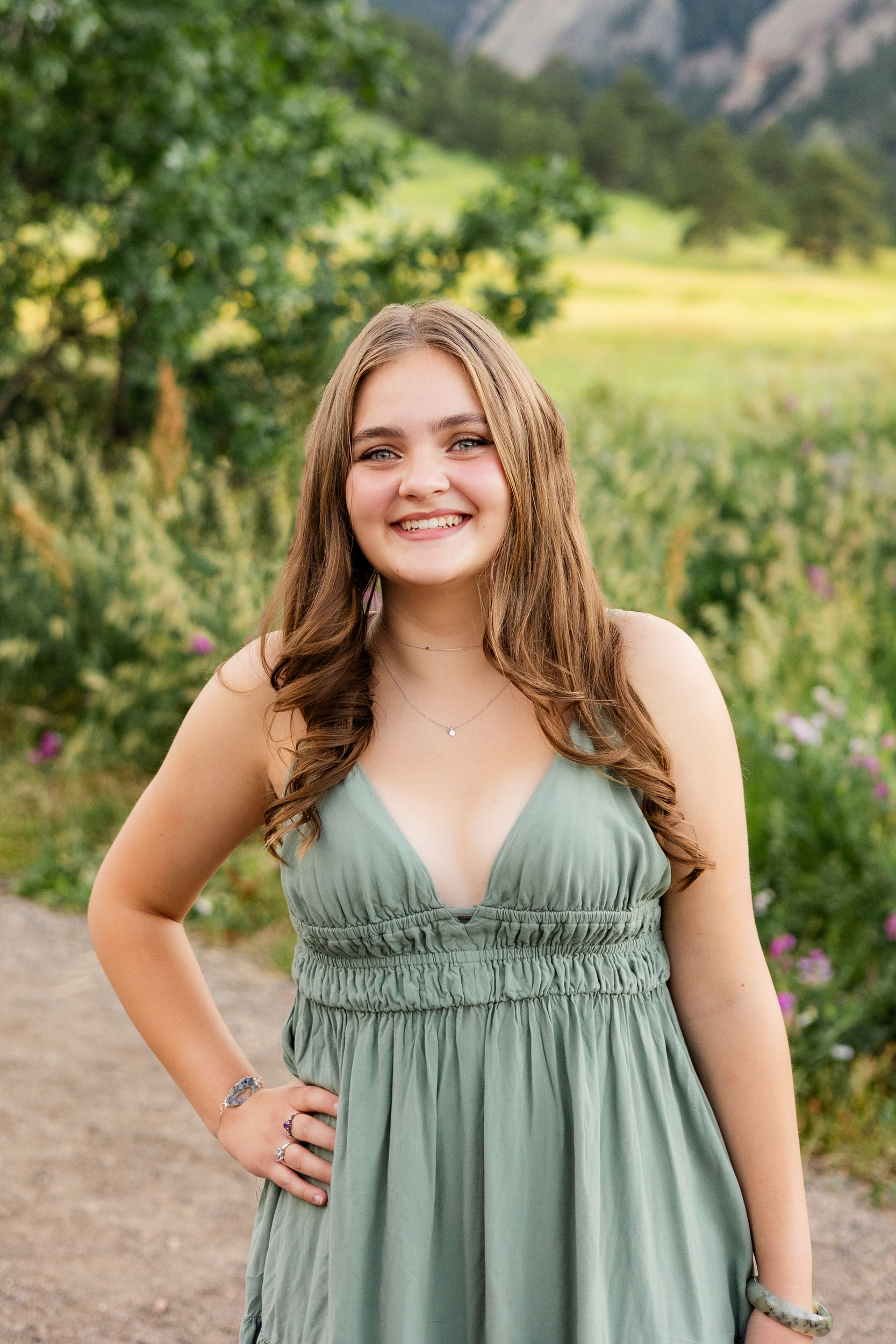 A woman in a green dress smiles at the camera.