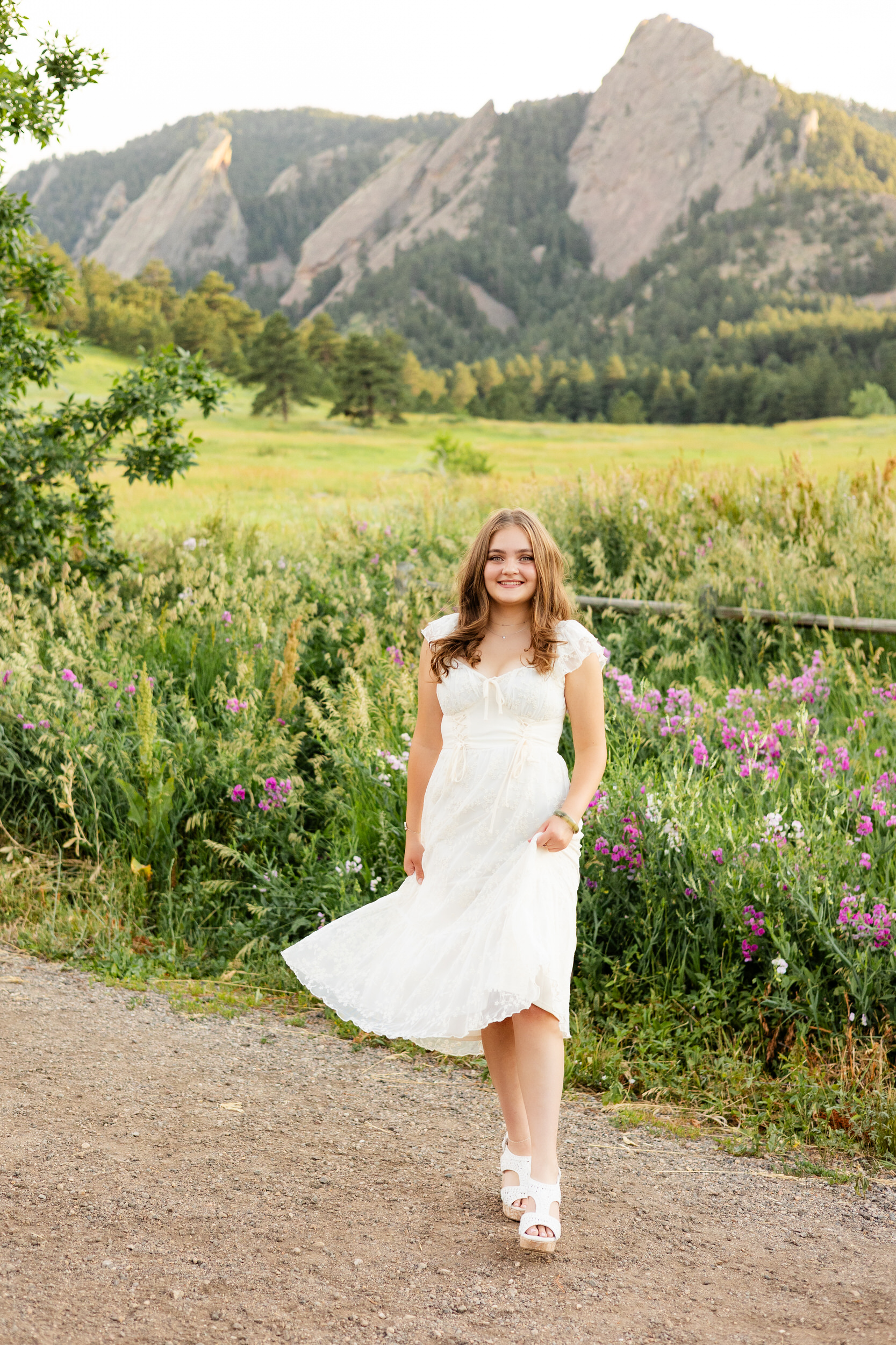 A woman in a white dress walks toward the camera.