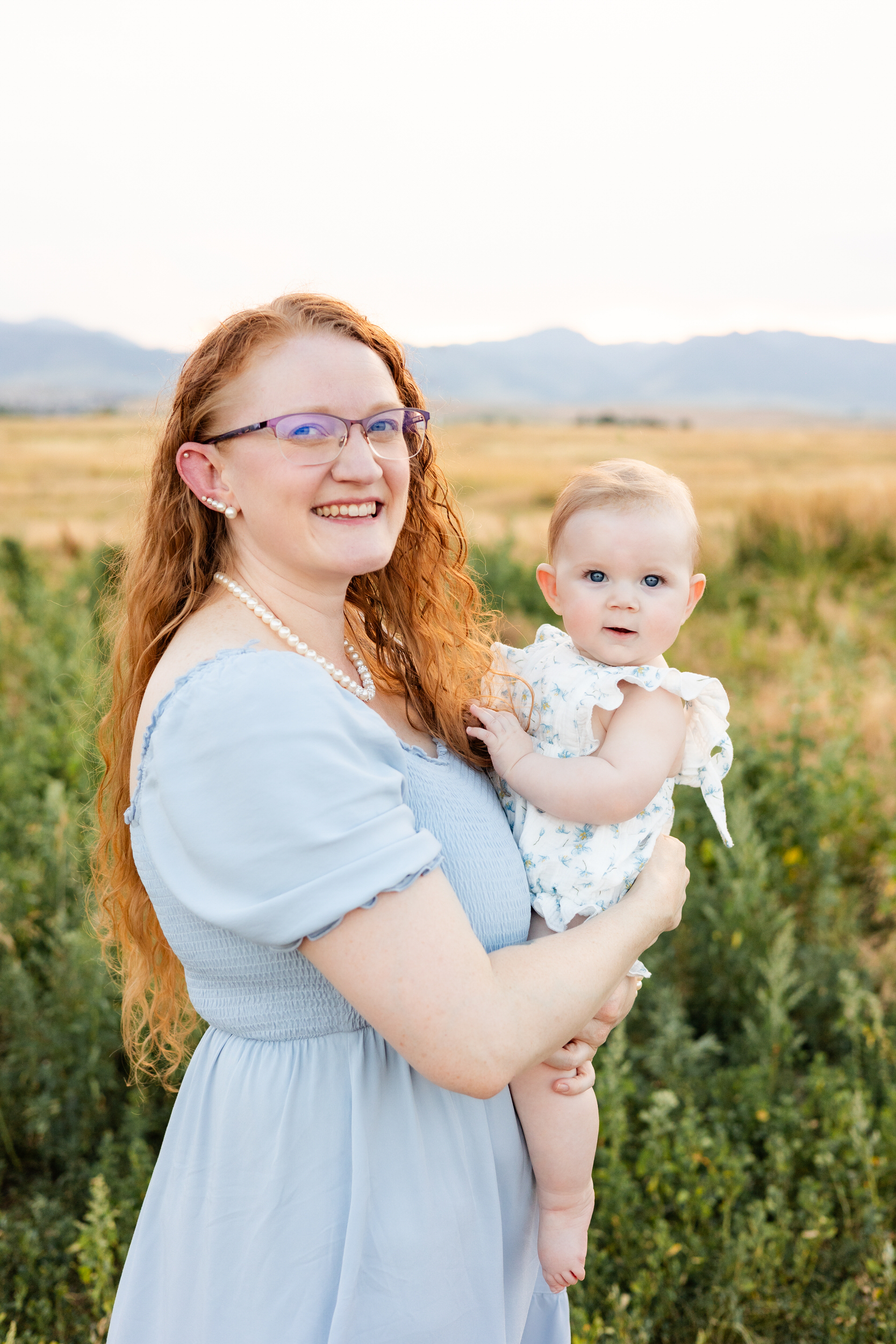 Mom and baby girl smile at the camera