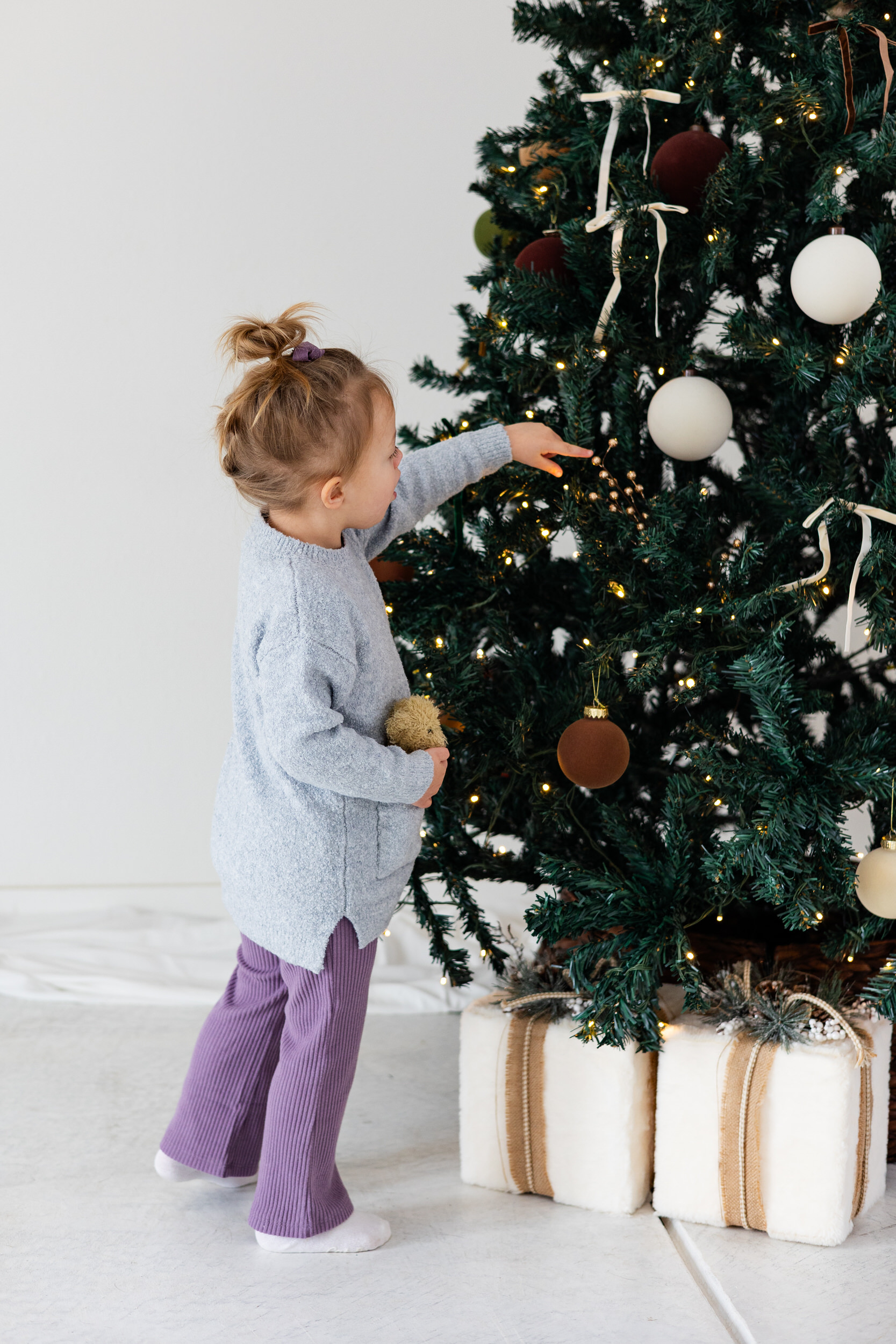 Little girl looking at Christmas tree.