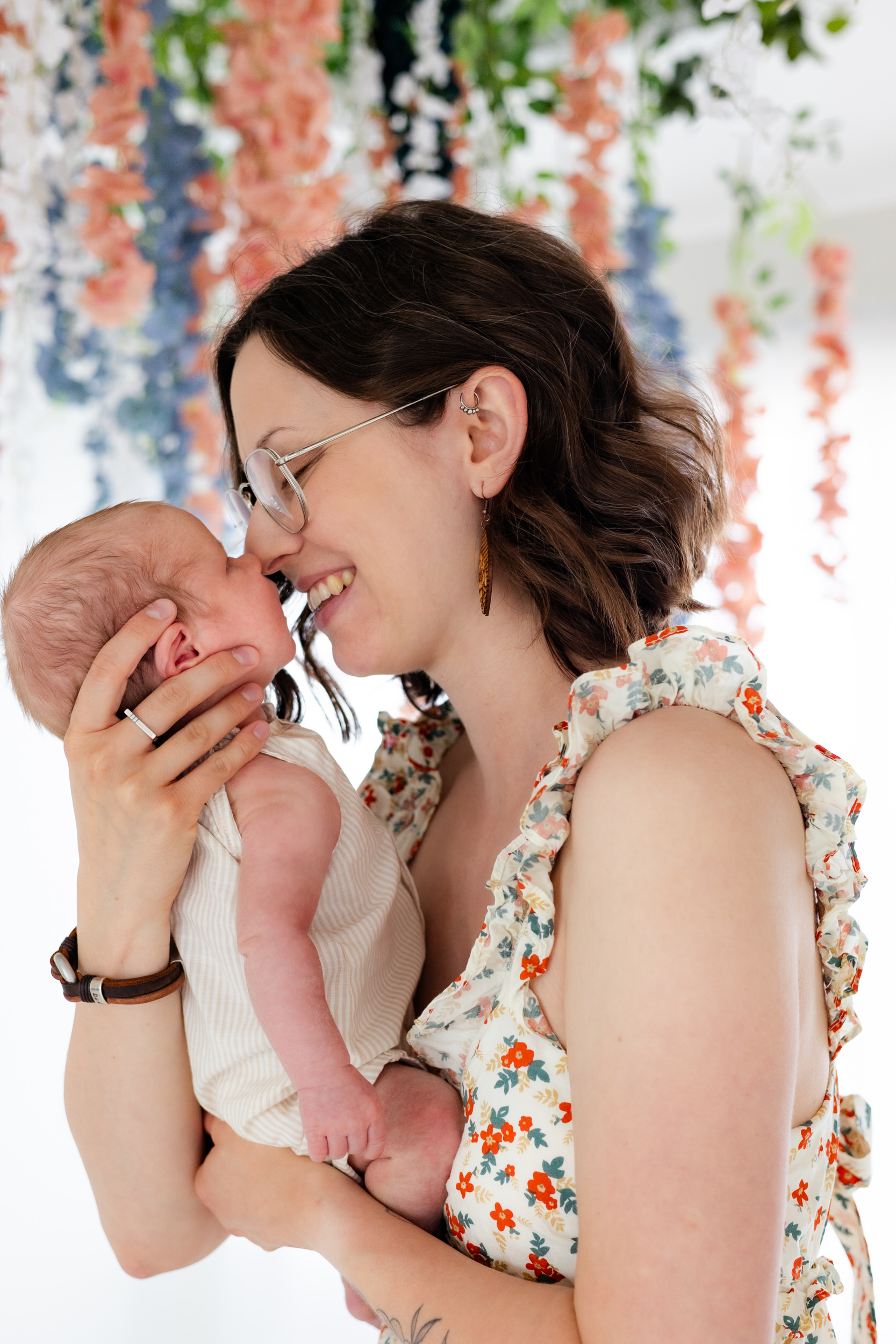 A mom gives her newborn baby Eskimo kisses.