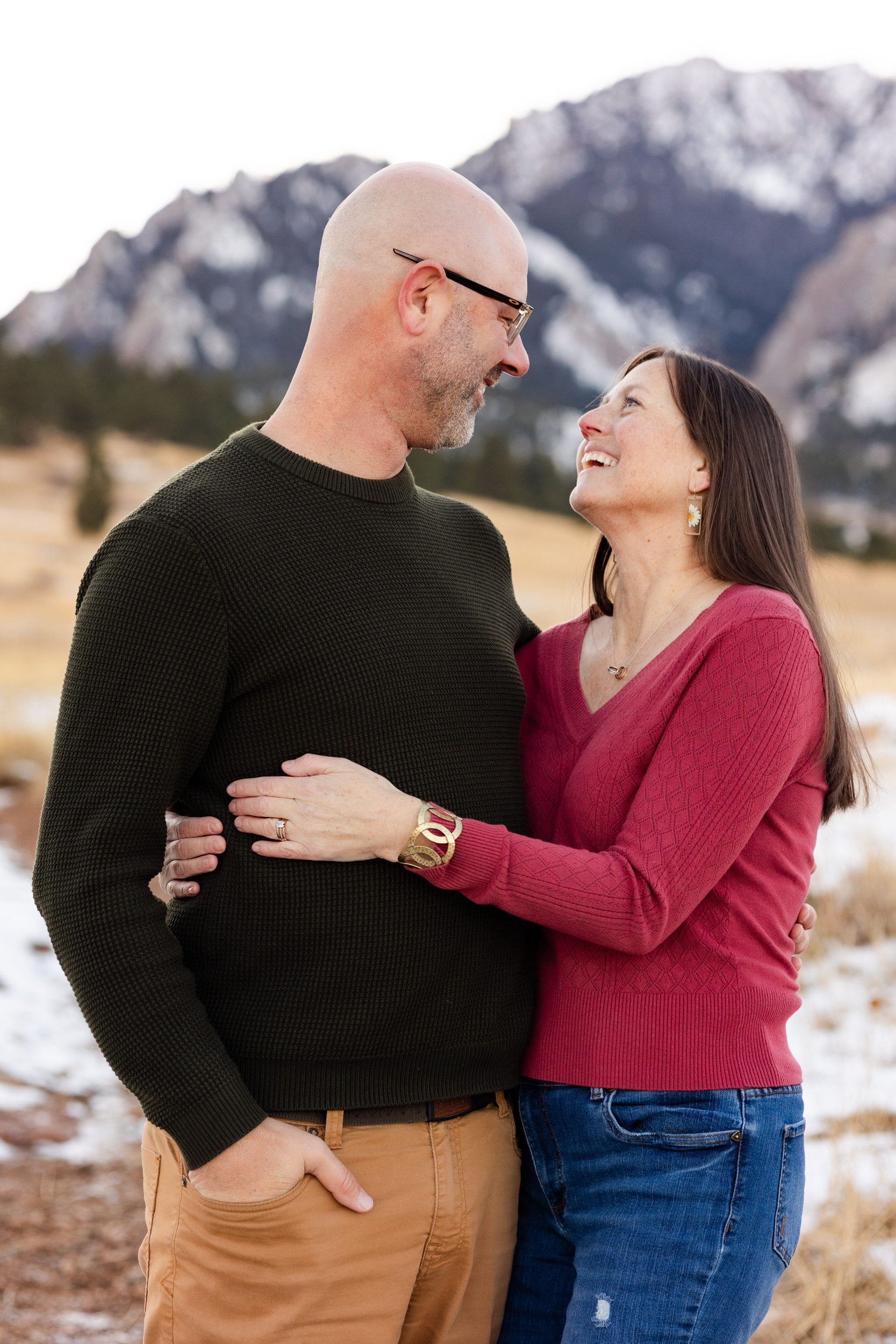 A husband and wife hold each other close and smile at each other.