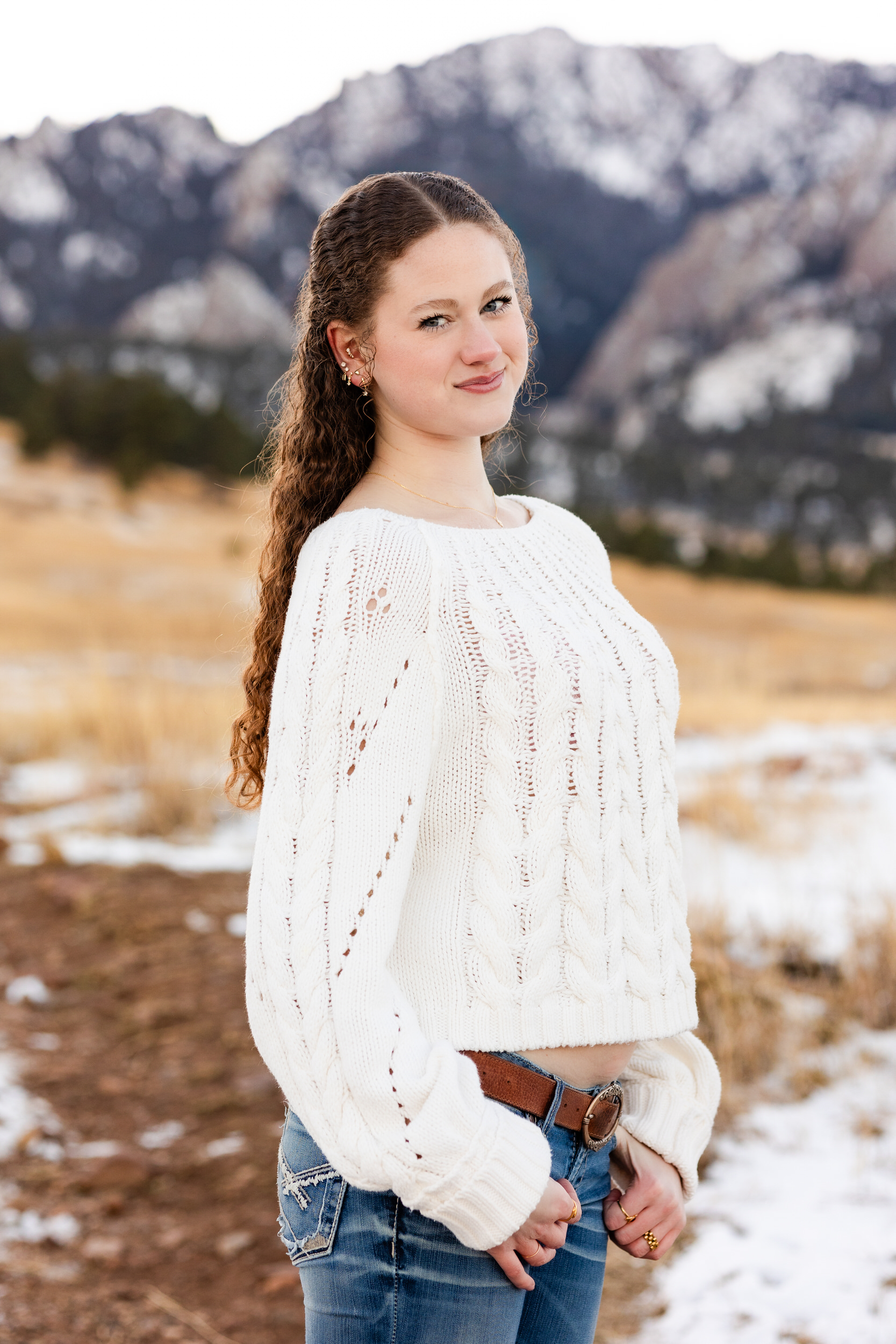 A young woman in a white sweater smiles at the camera.