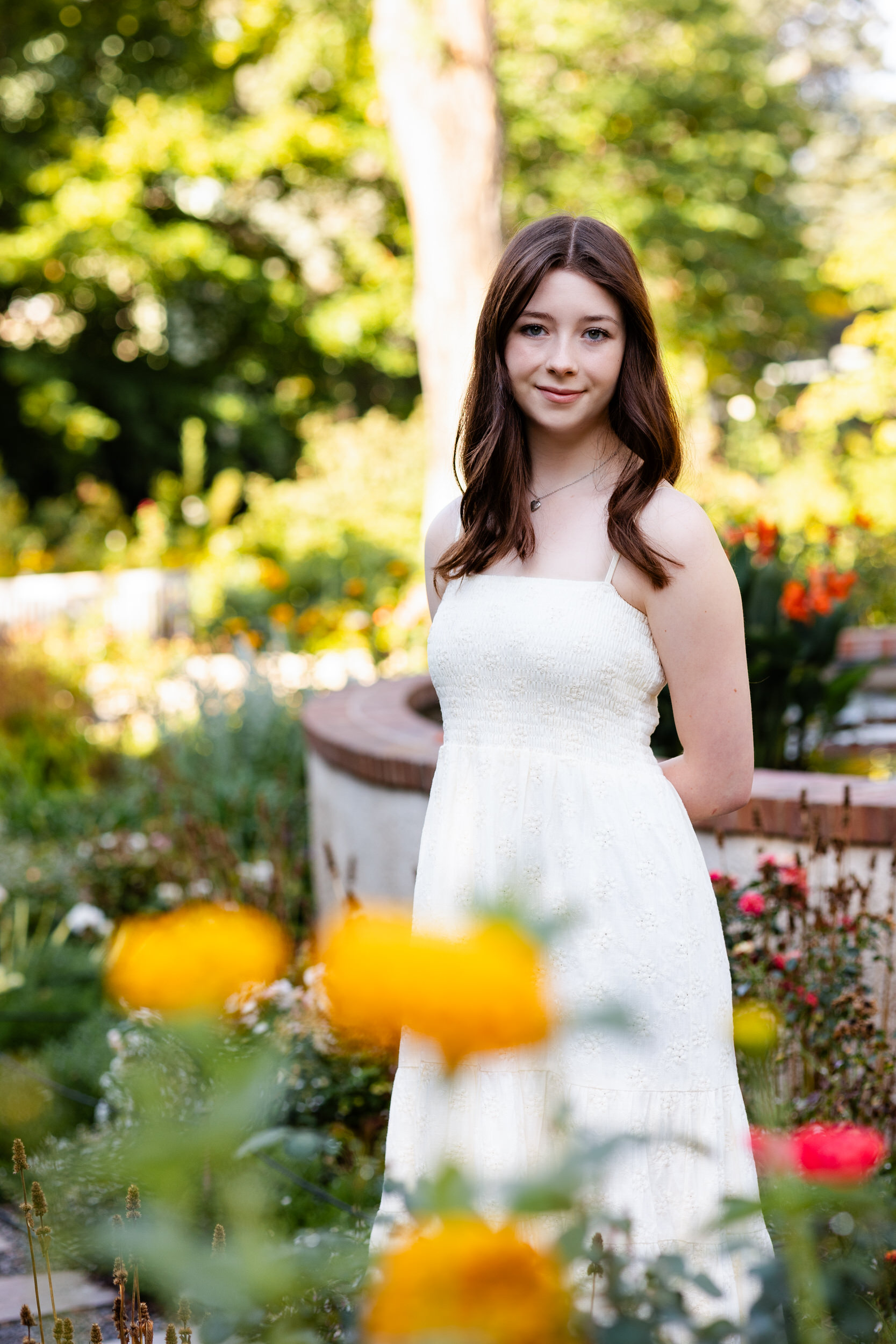 A young woman stands on a garden path and looks at the camera at the Denver Botanic Gardens.