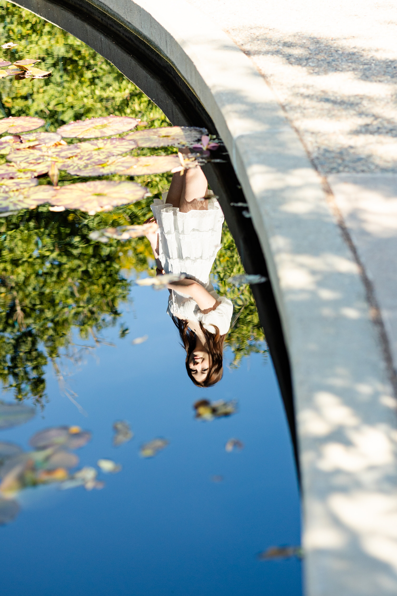 Reflection of a young woman in a white dress.