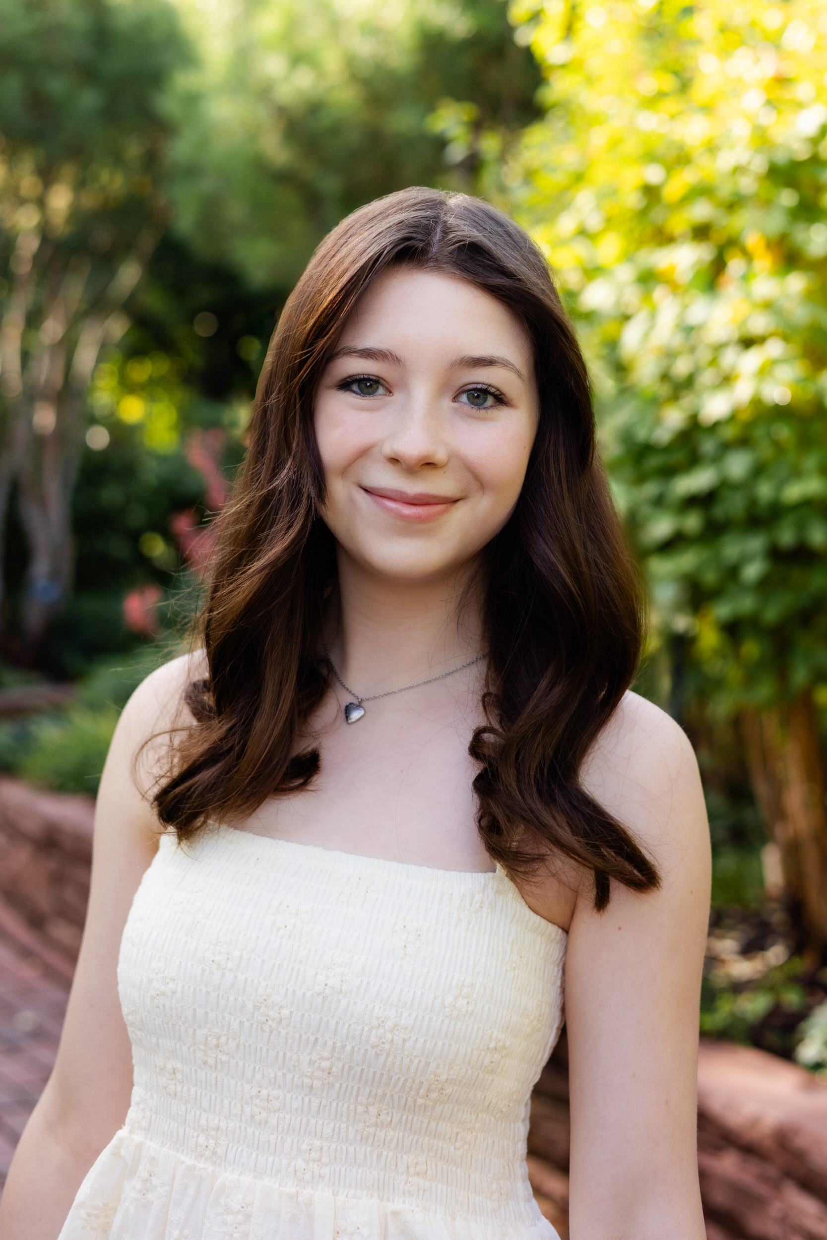 A young woman smiles at the camera in the Denver Botanic Gardens.