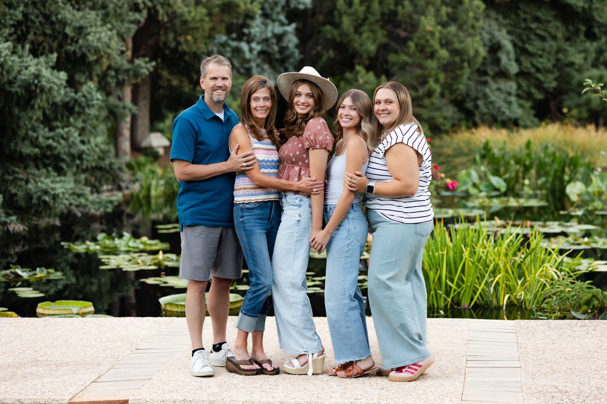 A mom and dad and three young adult women smile at the camera.