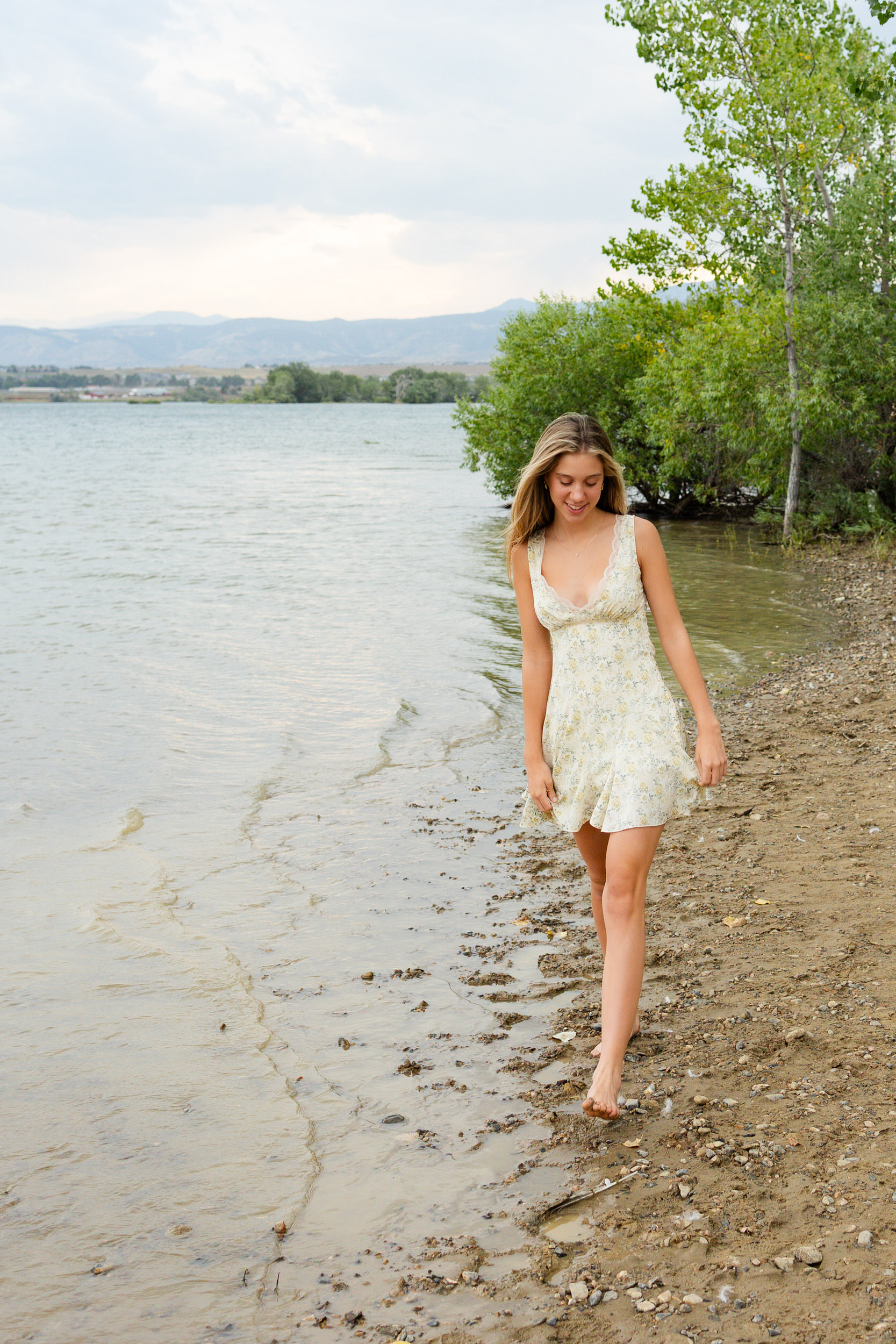 A young woman walks barefoot on a beach.