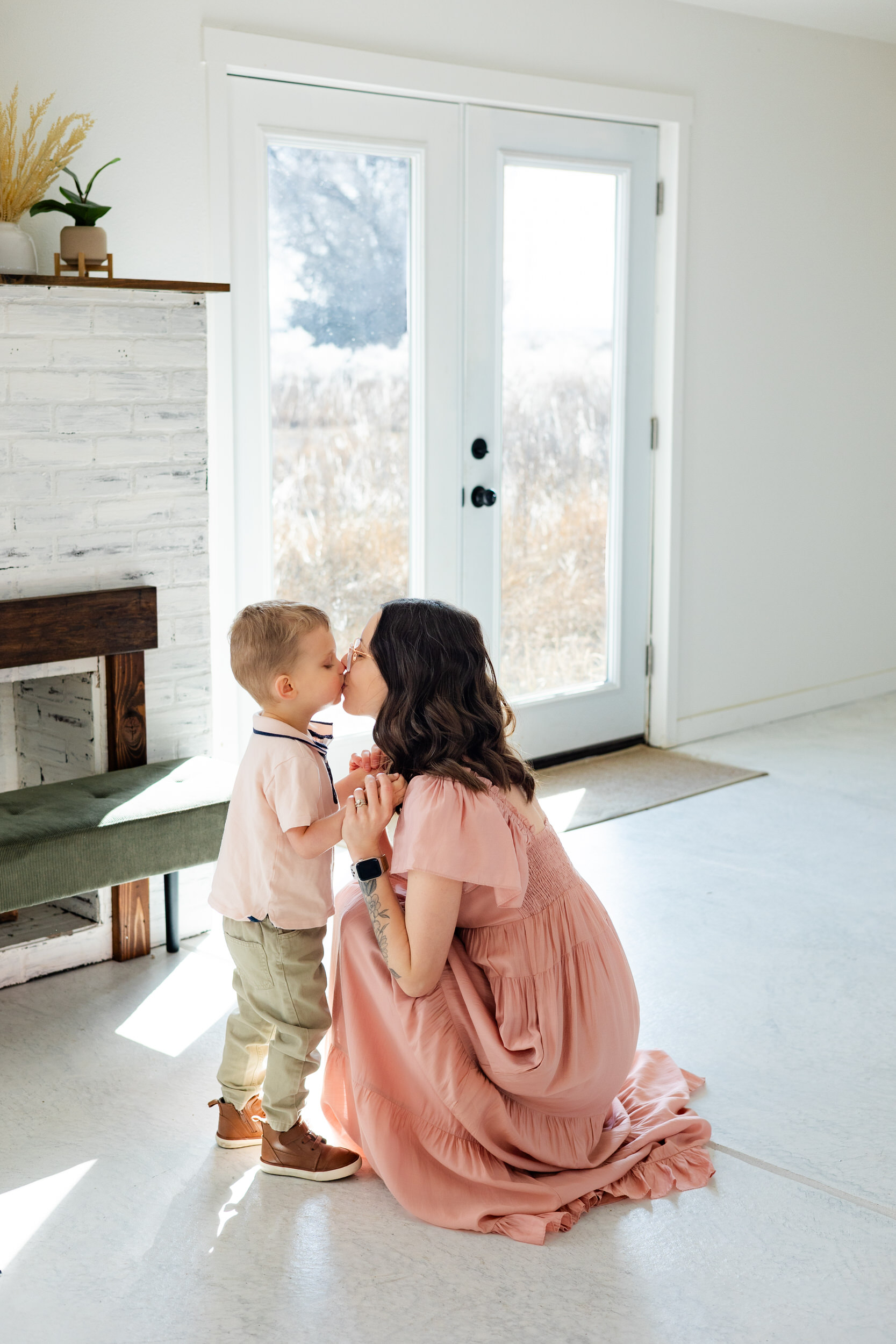 A mom and her toddler son share a kiss.