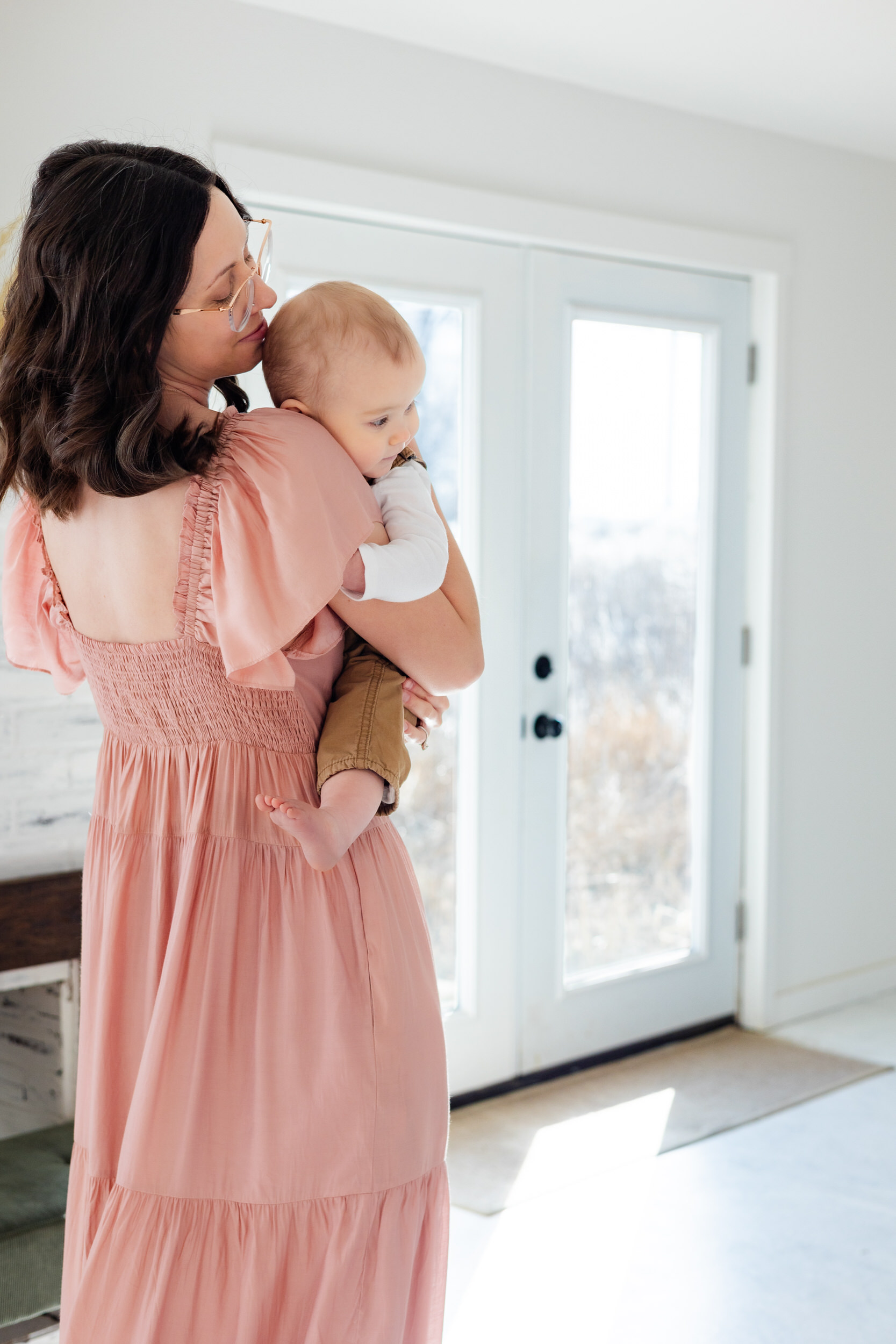 A mom holds her baby and smiles at him.