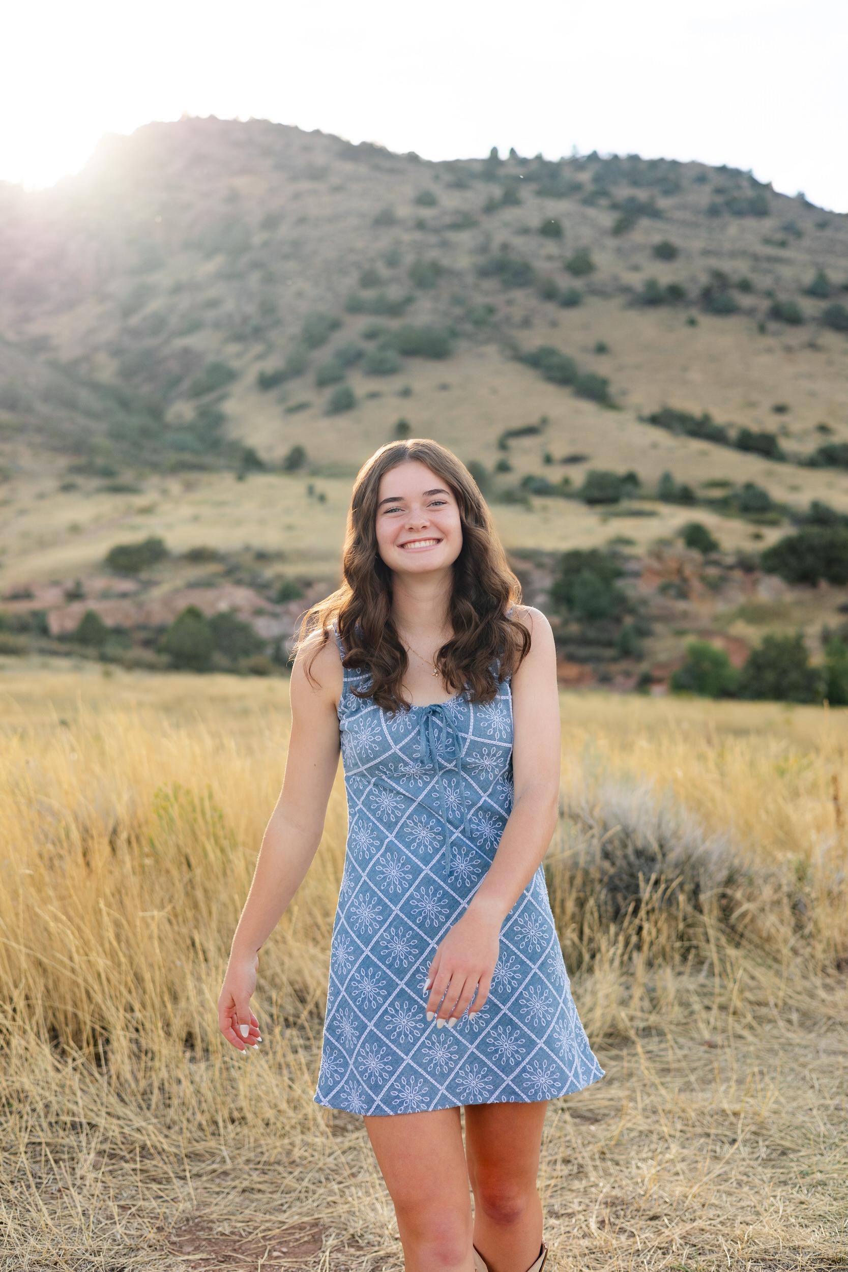 A young woman walks toward the camera and smiles.