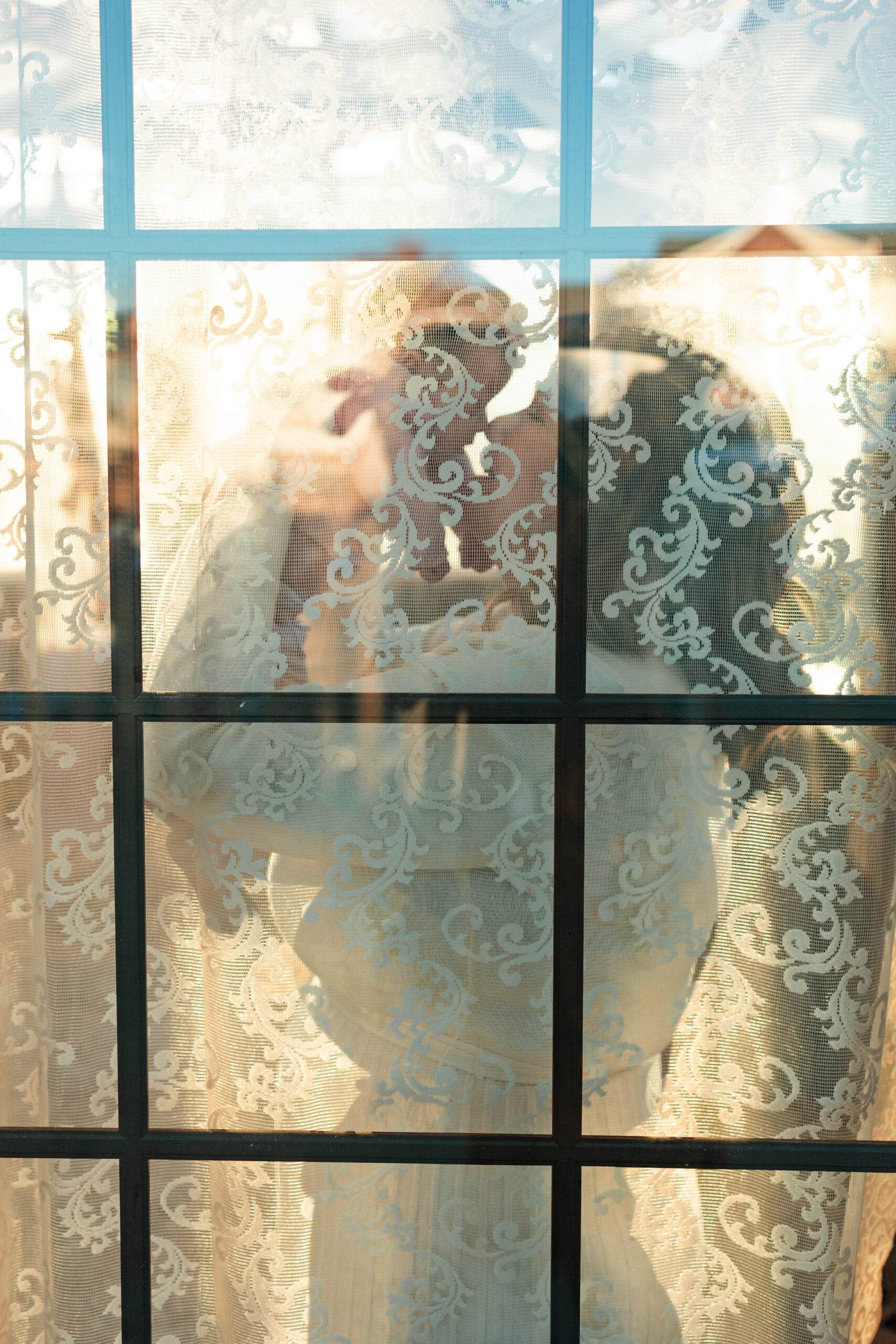 Silhouette of a mom kissing her newborn daughter.