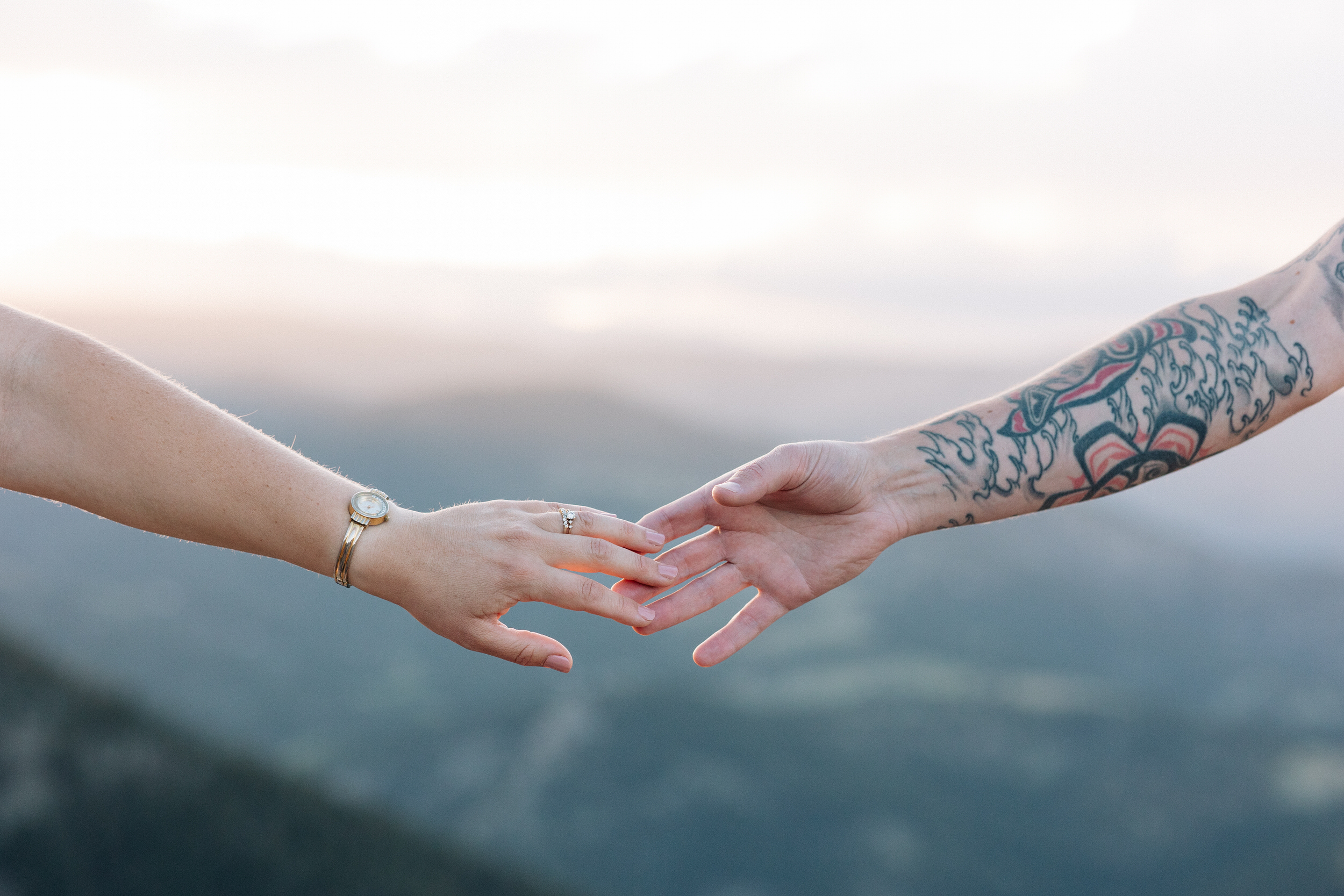 Close up of husband and wife's hands reaching for each other.