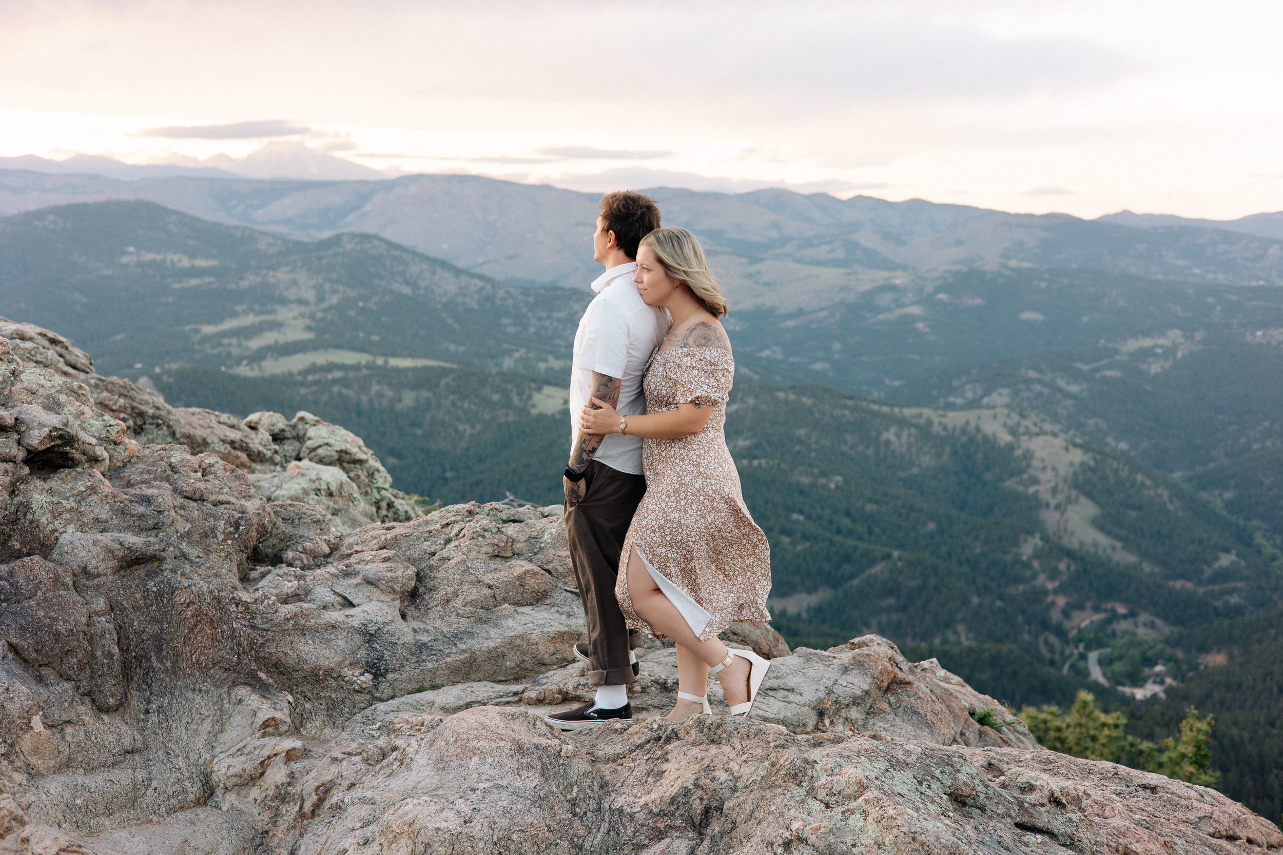 Wife rests her chin on her husband's shoulder as they take in the view at Lost Gulch Overlook in Boulder, Colorado.