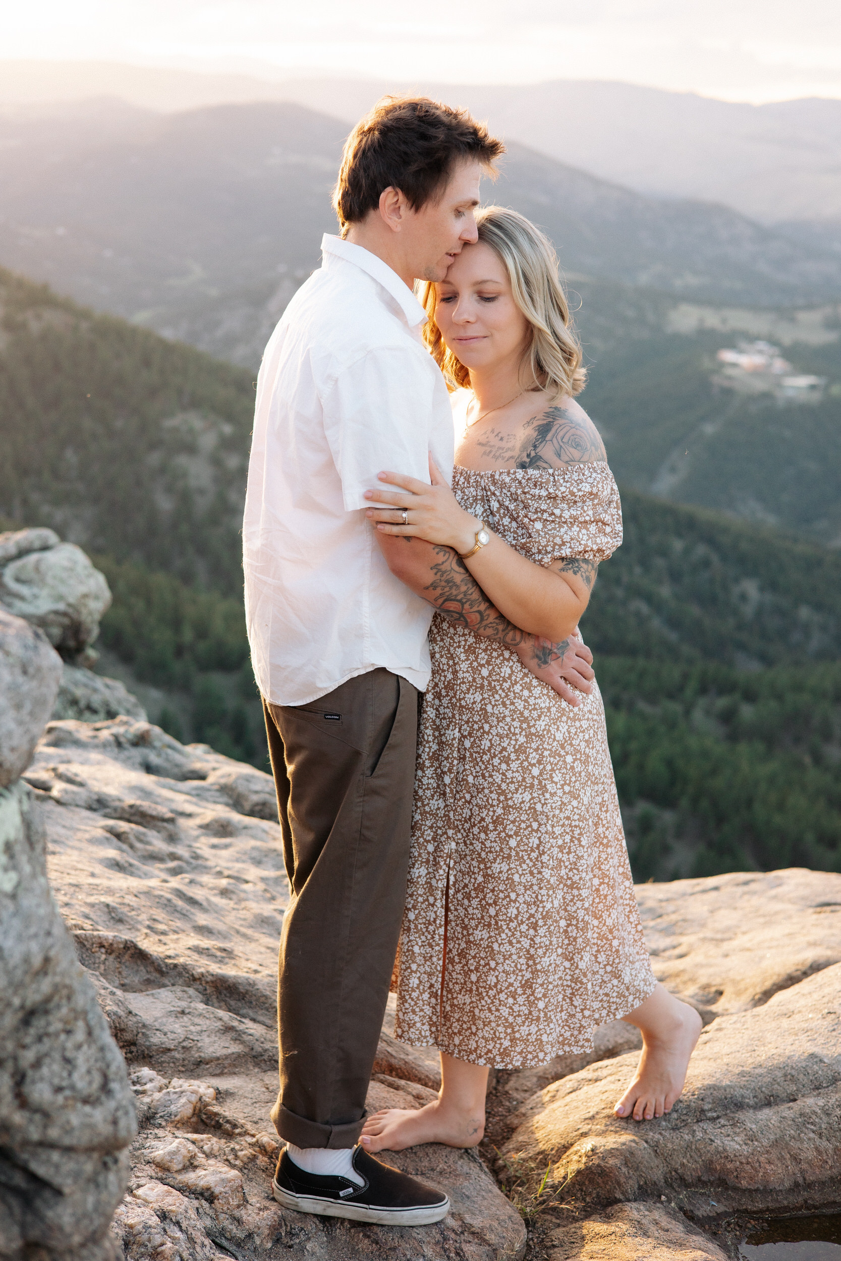 Husband kisses wife's forehead during their anniversary photos at Lost Gulch Overlook in Boulder, Colorado.