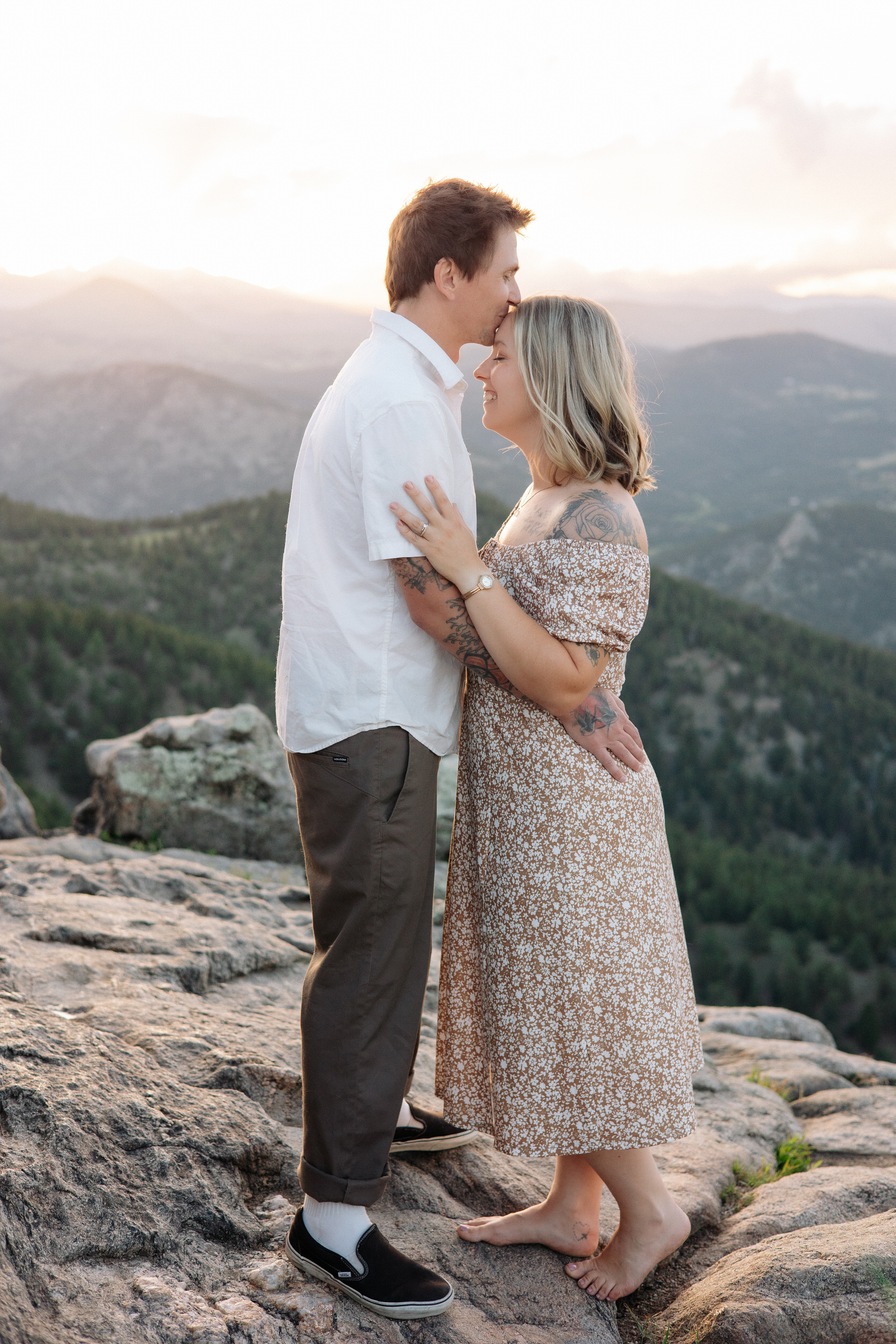 Husband kisses wife's forehead during their anniversary photos at Lost Gulch Overlook in Boulder, Colorado.