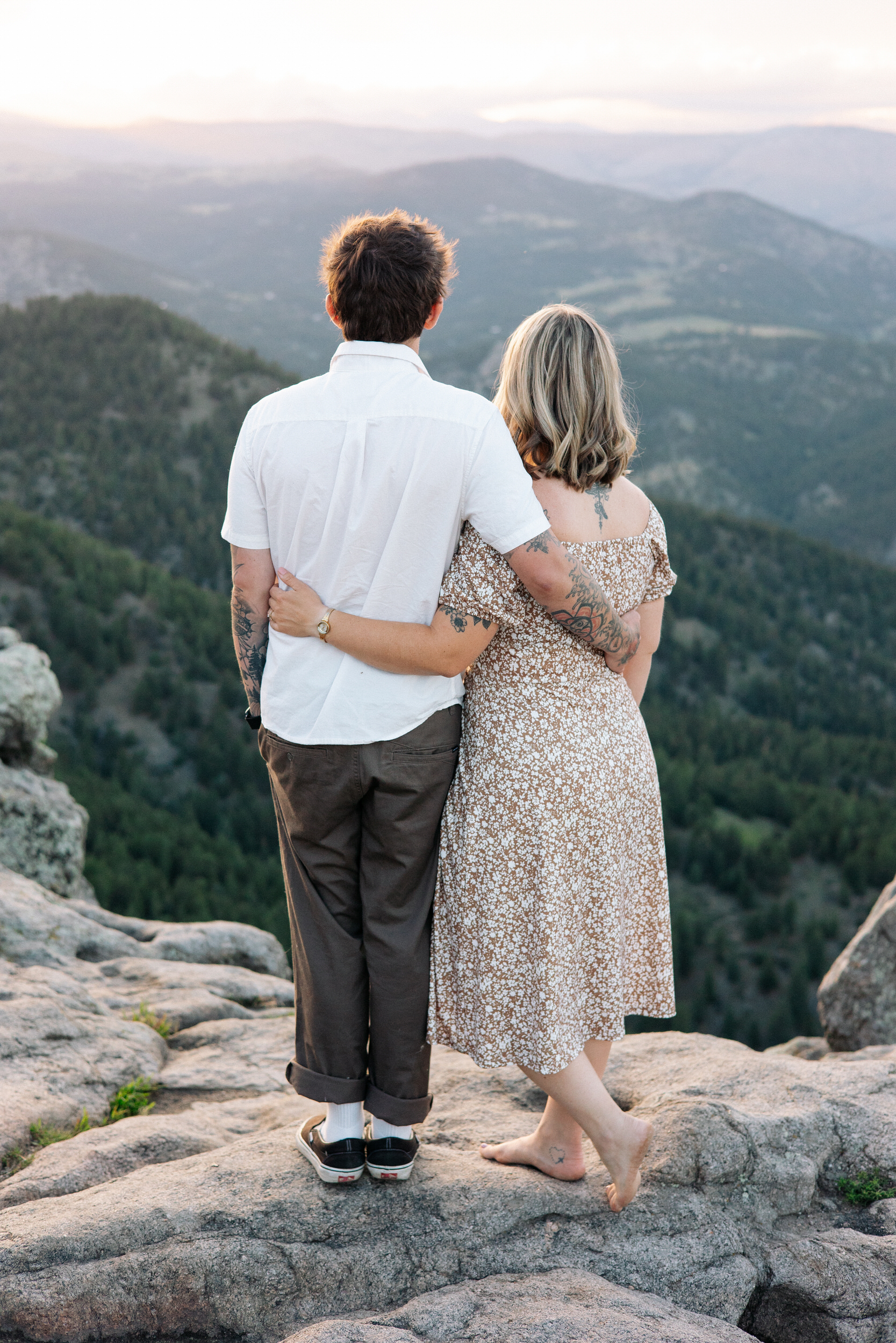 Husband and wife stand with their arms around each other's waist as they look at the view at Lost Gulch Overlook in Boulder, Colorado.