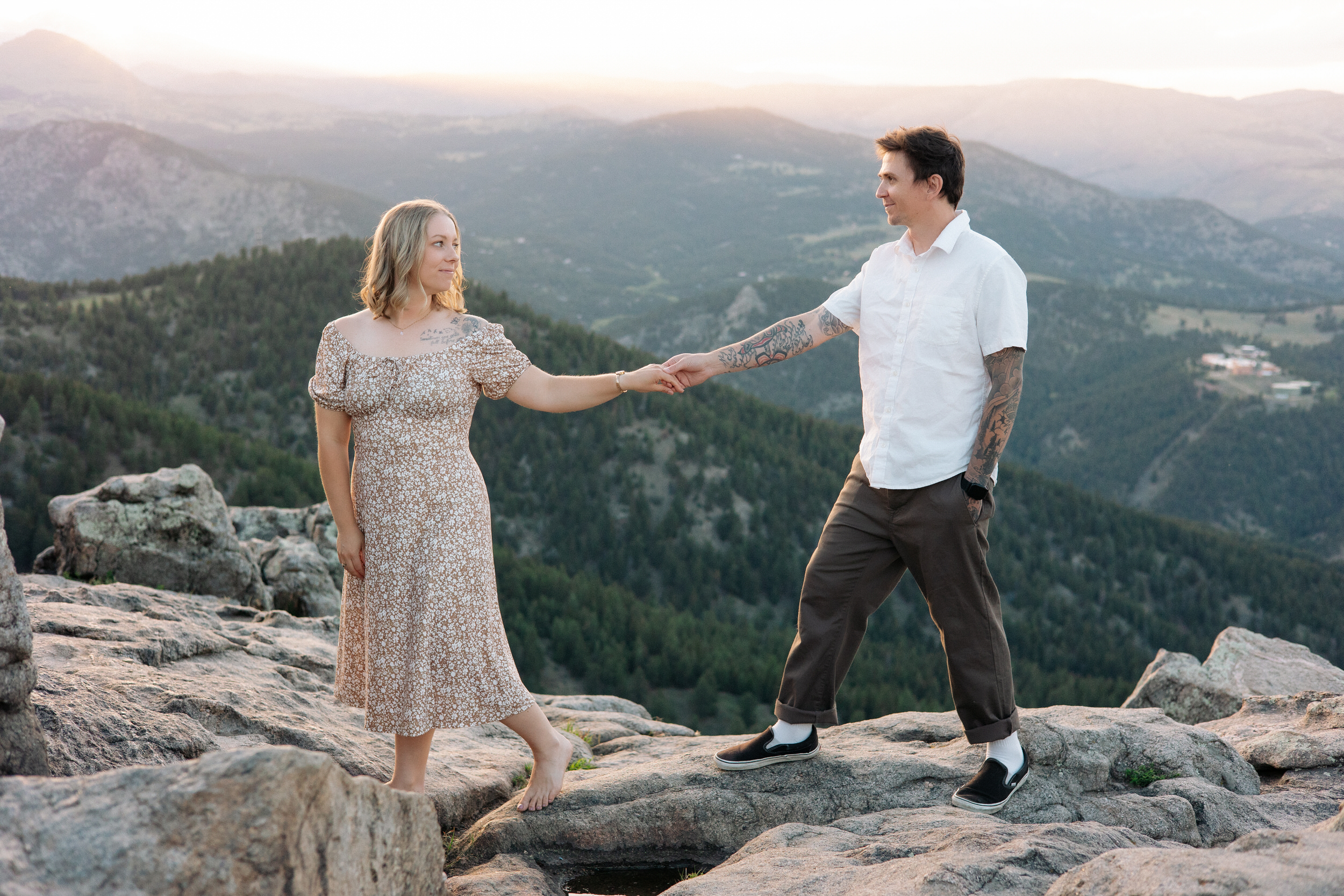 Husband and wife hold hands on a mountain top at Lost Gulch Overlook in Boulder, Colorado.